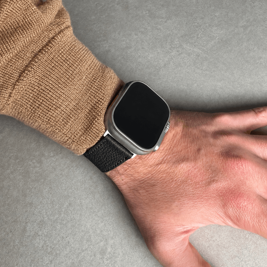 Schwarzes Lederarmband für Apple Watch aus Togoleder, am Handgelenk eines Mannes, stilvoll und elegant.