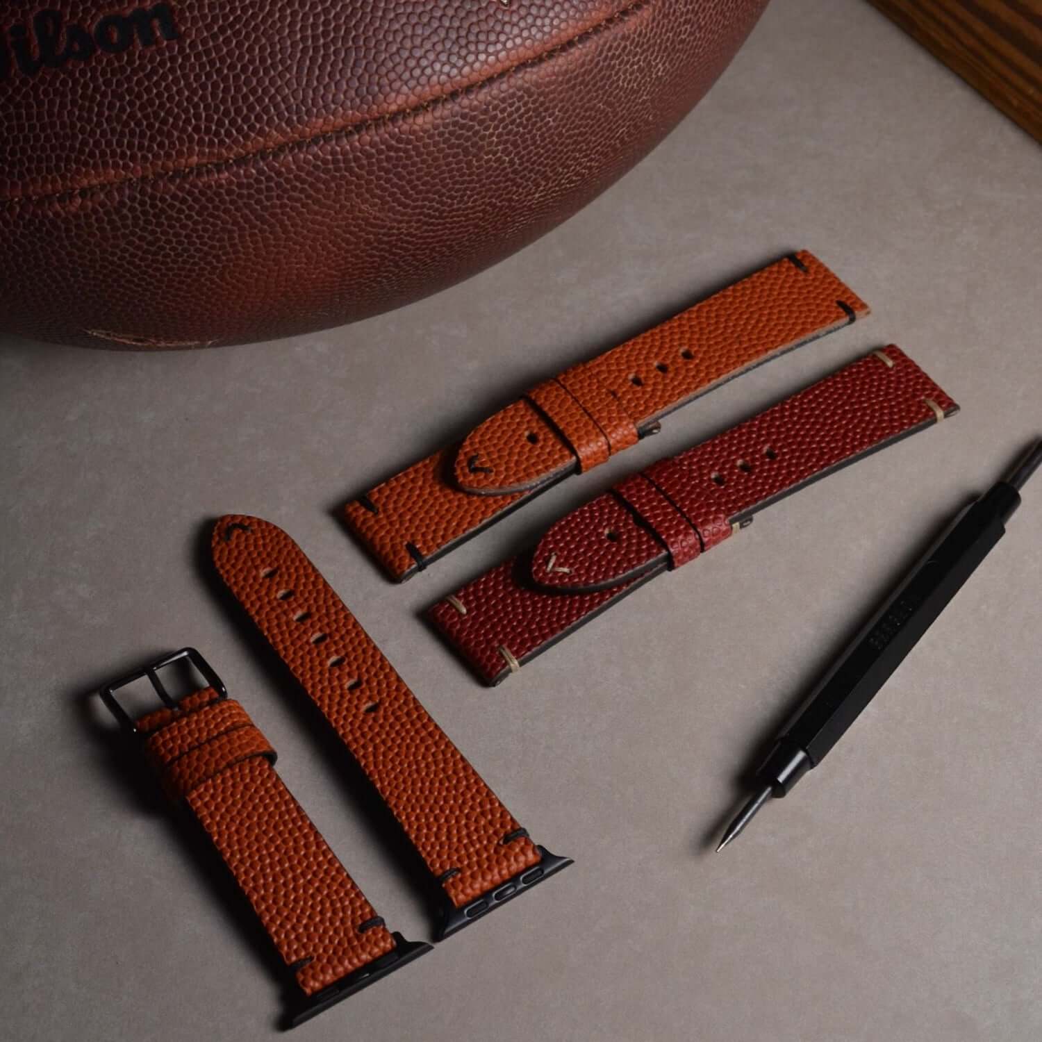 Courtside – Handgefertigt aus original Horween Basketballleder Apple Watch Armband mit Werkzeug und Basketball im Hintergrund.
