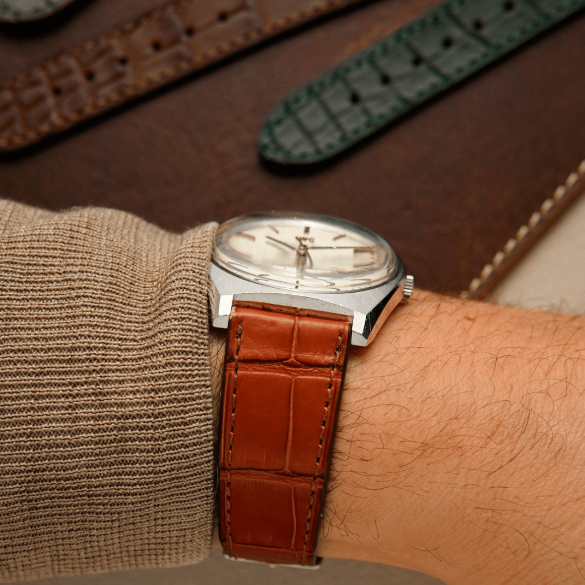 Luxuriöses Louisiana Alligator Uhrenarmband am Handgelenk, handgefertigt aus Bauchteil in Cognac-Farbe, traditionelle Handwerkskunst.