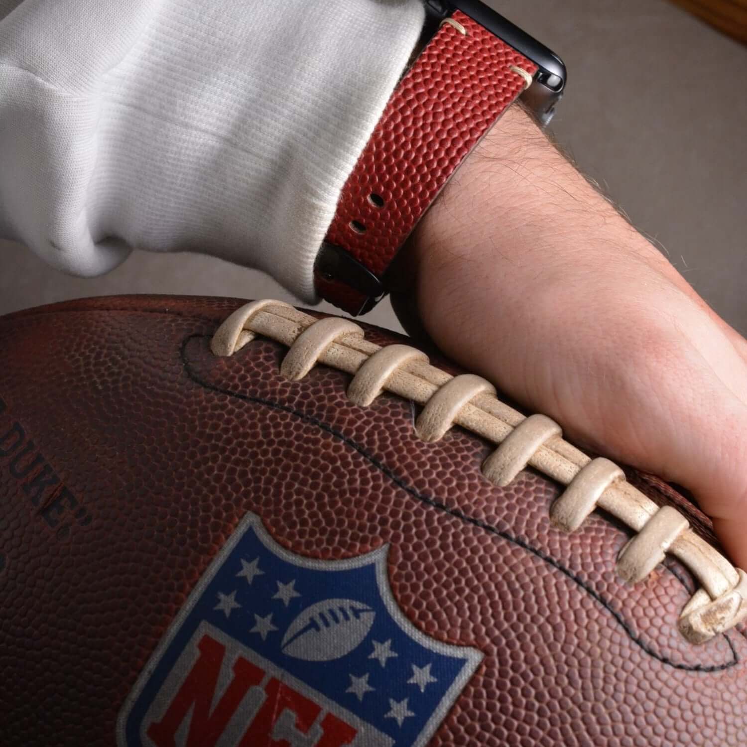 Apple Watch Band aus Wilson – Handgefertigt aus original Horween Footballleder auf einem Football.