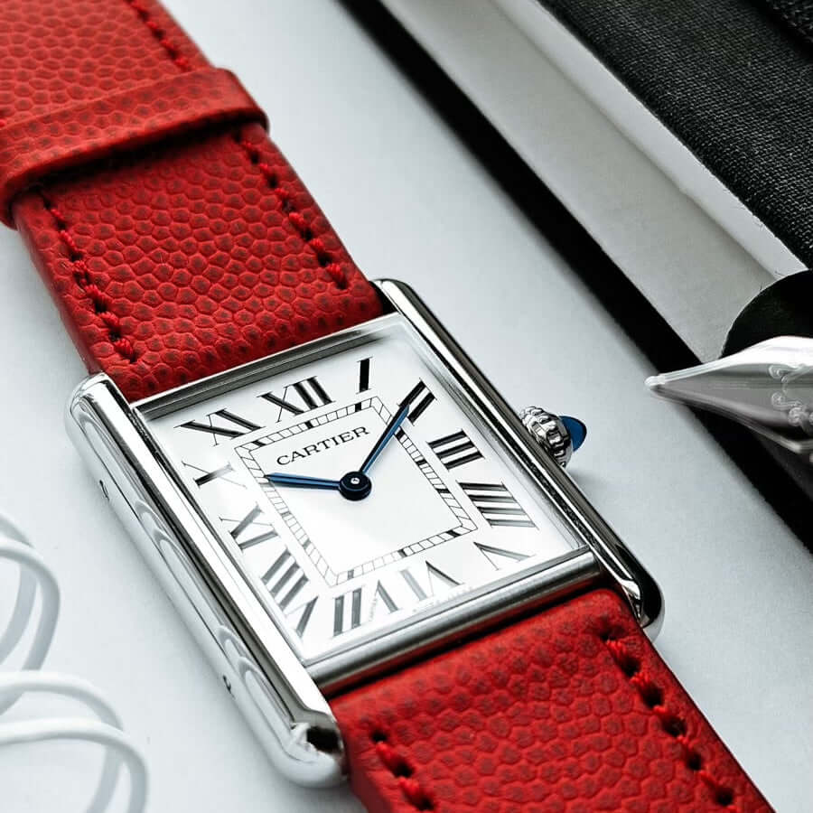 Luxury watch with a red textured leather strap and Roman numeral dial, showcasing elegant design and sophistication.