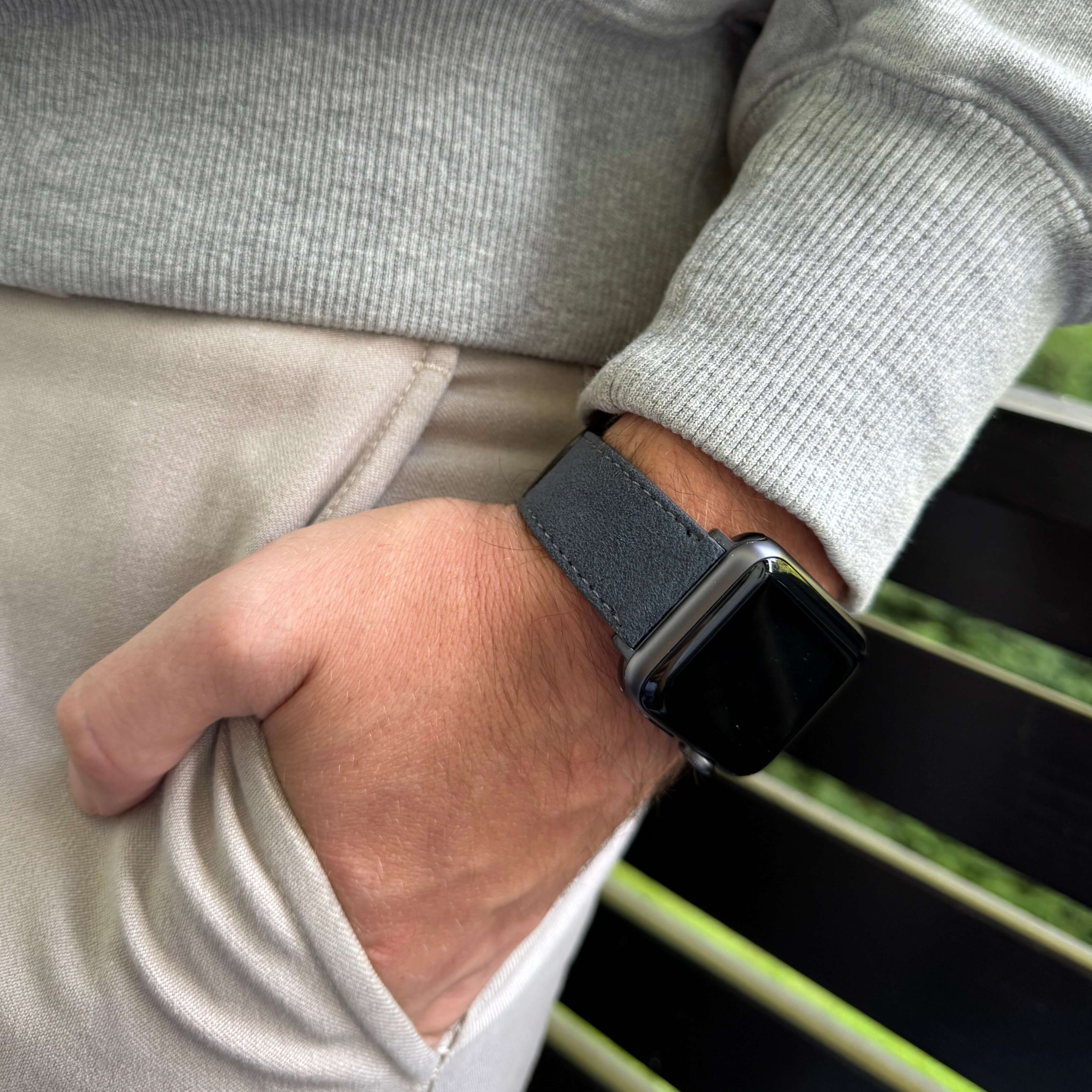 Person trägt Apple Watch mit schwarzem Alcantara Armband, ideal für Stil und Komfort.