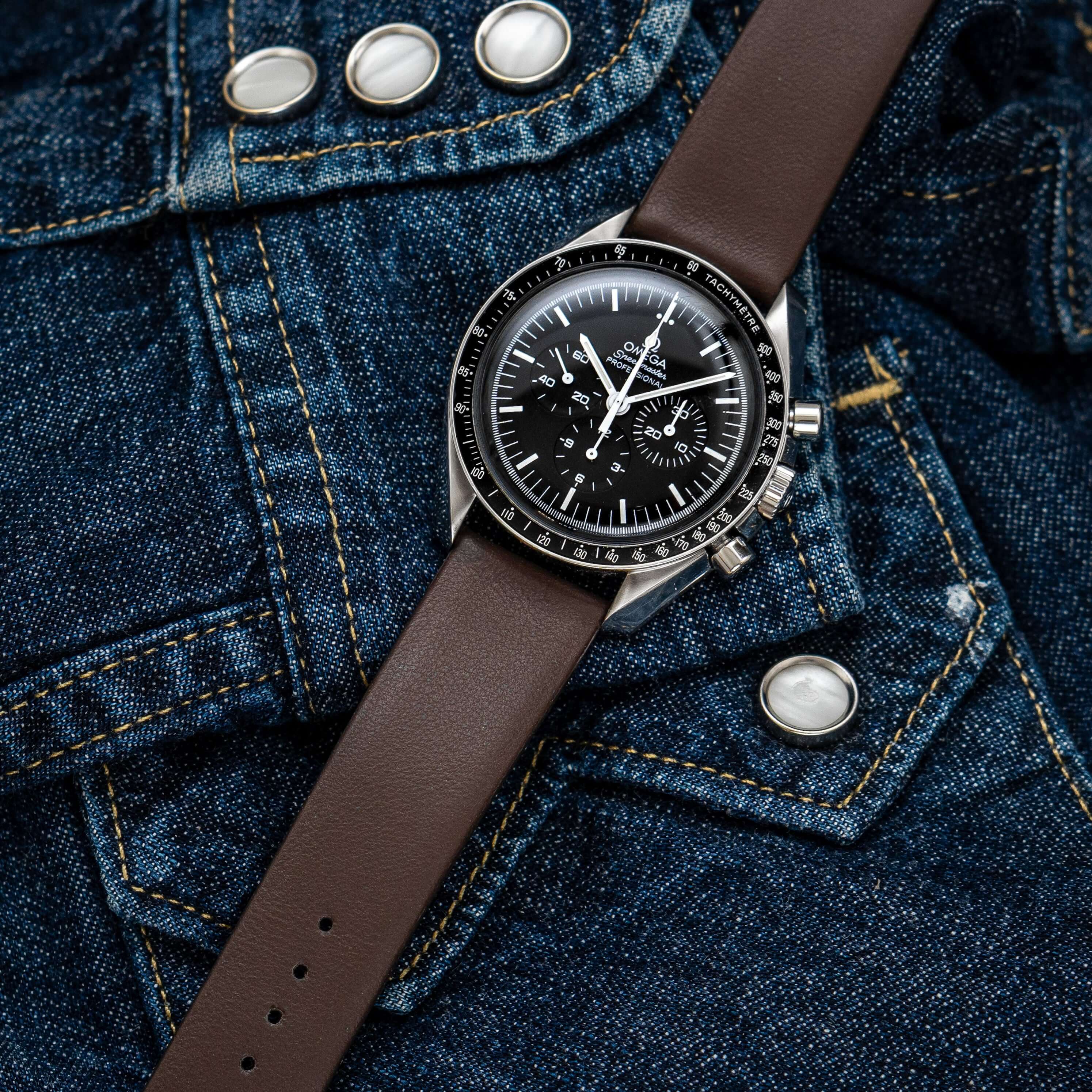 Design – Armband aus feinem Glattleder mit samtigem Griff an einer Omega Speedmaster auf Jeansjacke