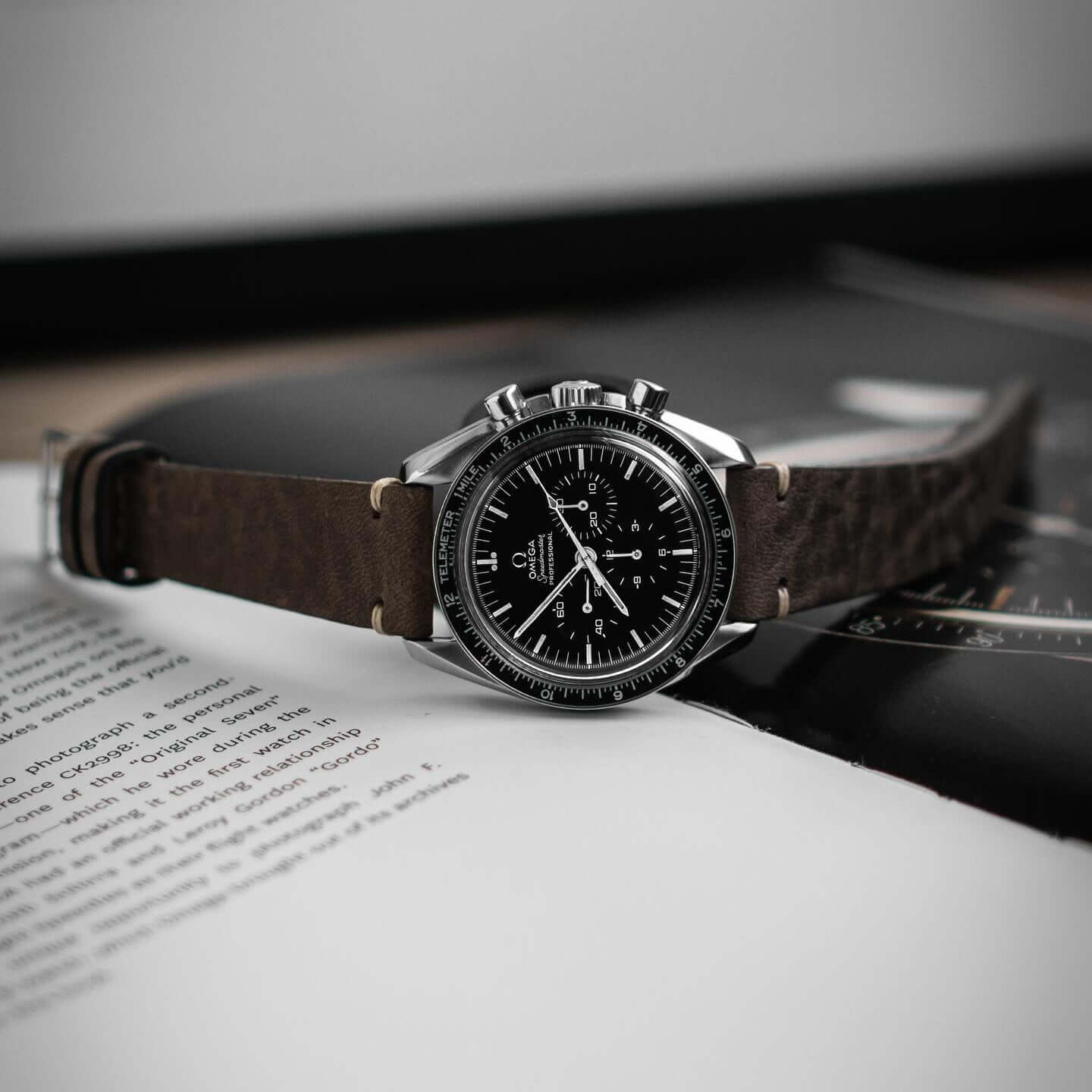 Hunter – Uhrenarmband aus toskanischem Vintage-Rindleder an einer klassischen Armbanduhr auf einem aufgeschlagenen Buch