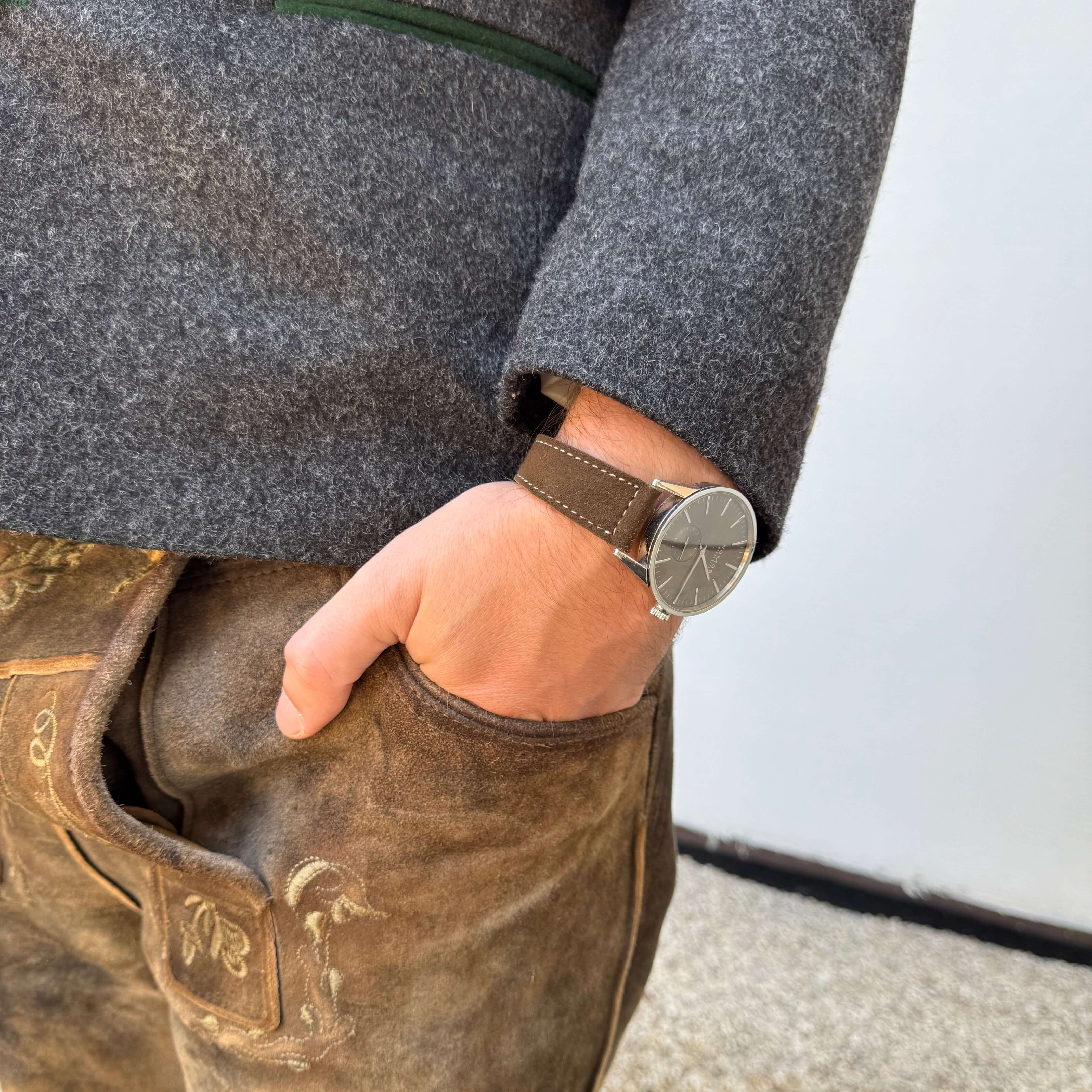 Mann trägt 20mm Uhrenarmband aus echtem Lederhosenleder – altsämisch gegerbtes Hirschleder, passend zu traditioneller Tracht.