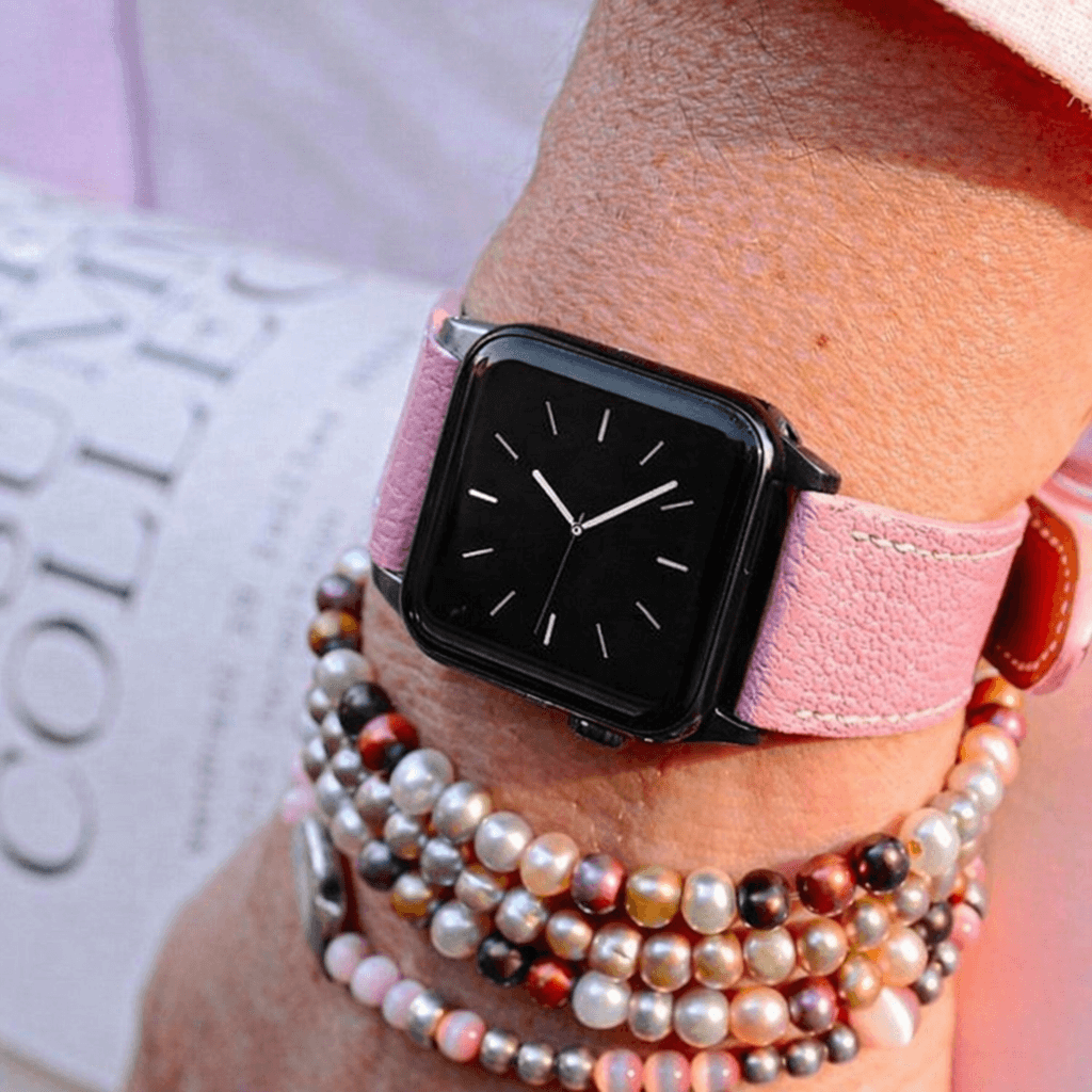 Rosa kurzes Apple Watch Armband- Biarritz an einem Handgelenk mit modischen Armbändern kombiniert.