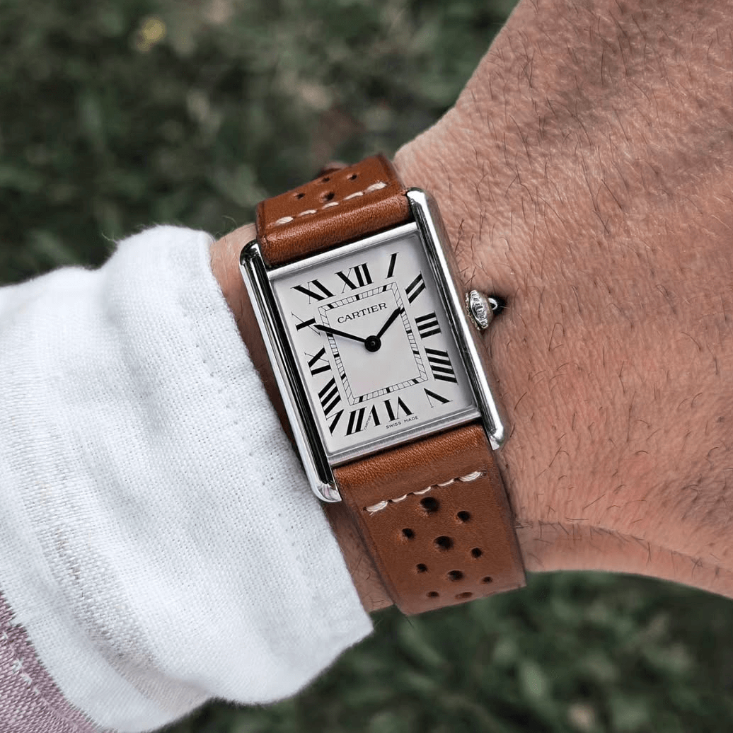 Mann trägt Paris Racing – Armband aus Barenia-Leder mit sportlicher Lochprägung und eleganter Uhr.