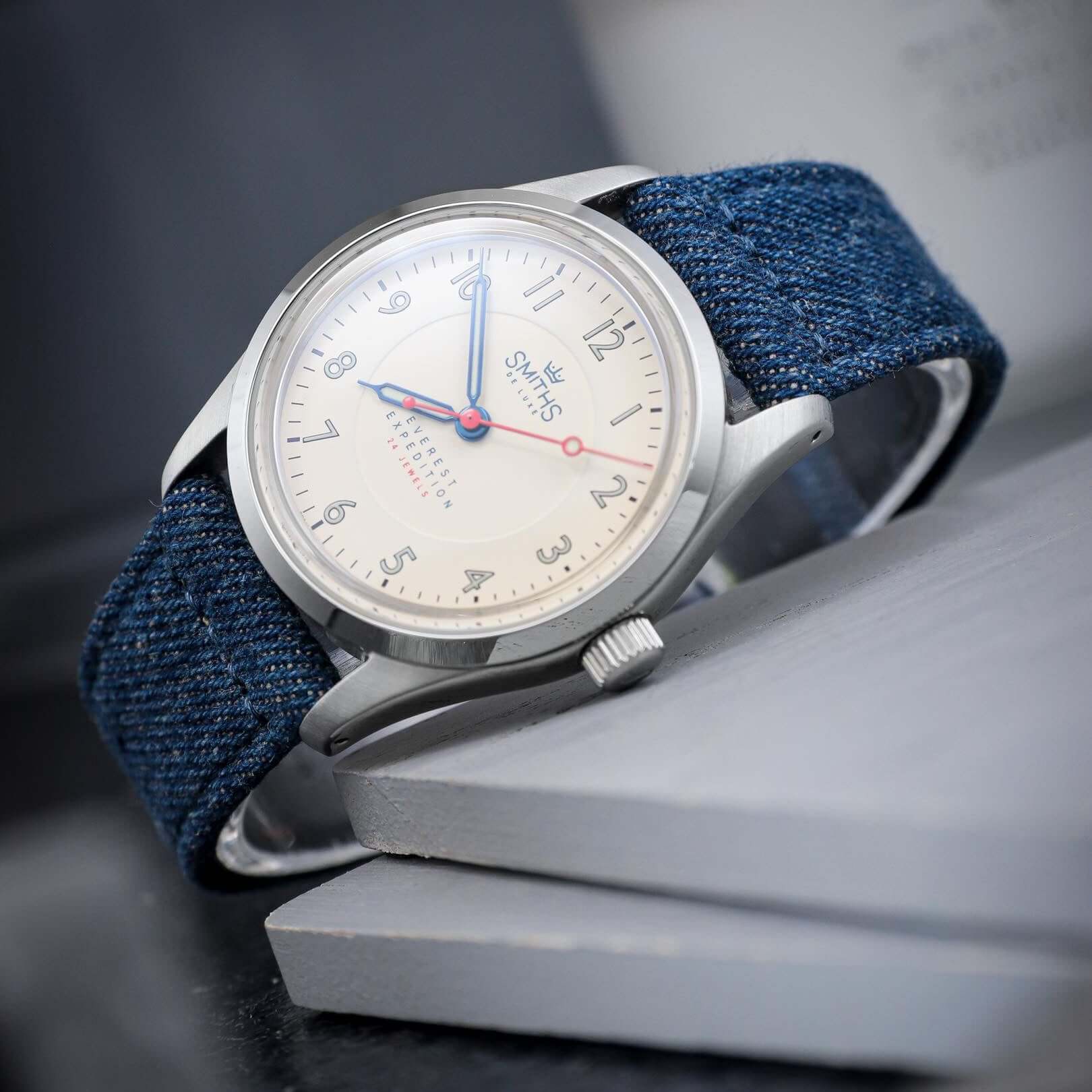 Jeans Uhrenarmband aus japanischem Denim an einer Uhr mit blauen Ziffern und silbernem Gehäuse, urbaner Stil kombiniert mit Handwerkskunst.