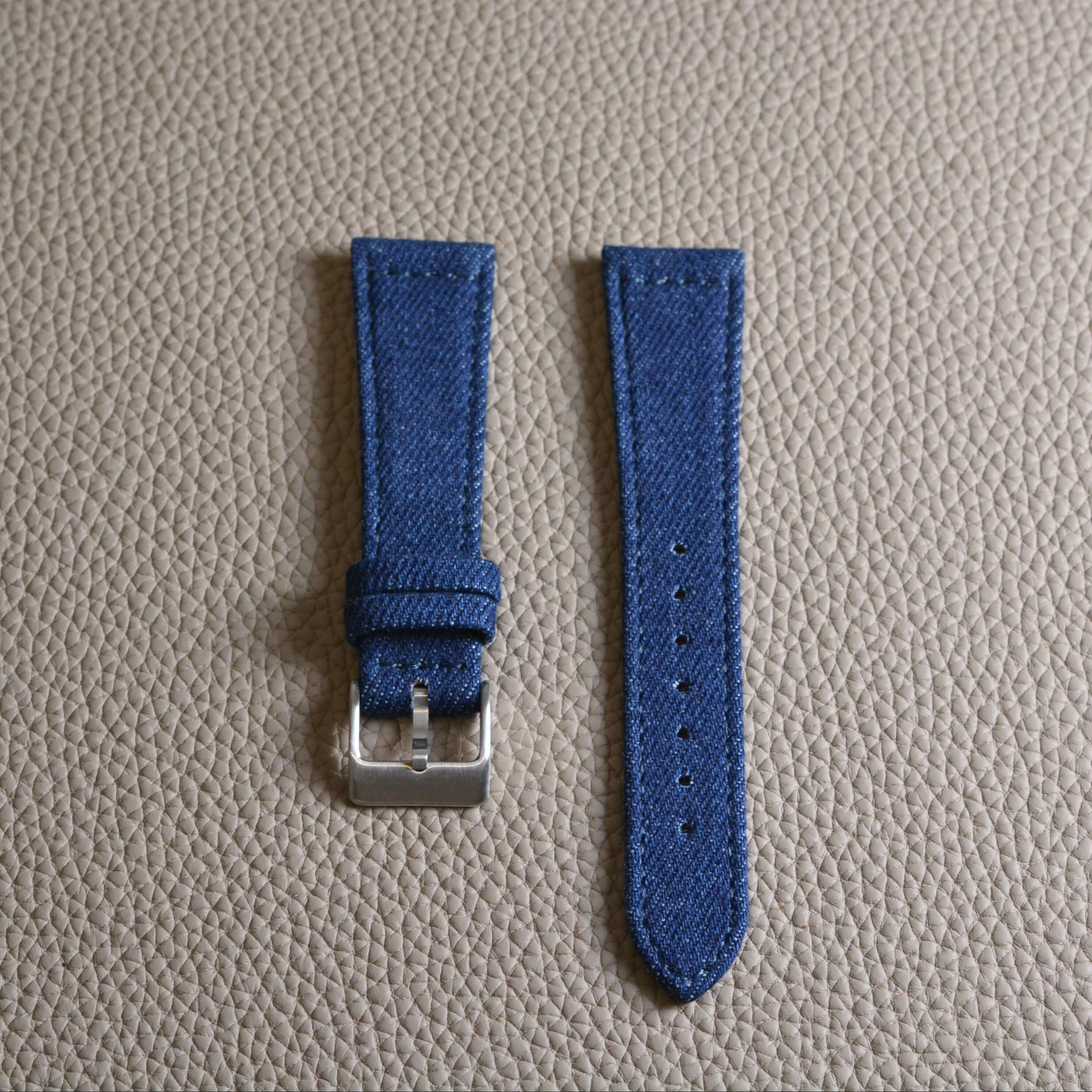 Jeans Uhrenarmband aus japanischem Denim mit schwarzem Kalbleder auf heller Lederoberfläche