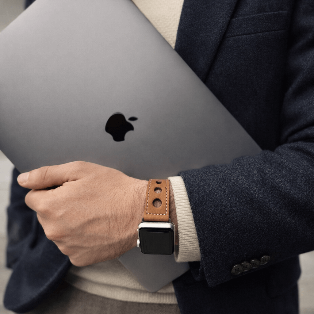 Cognac Rallye Apple Watch Lederarmband im Panerai-Stil am Handgelenk, passend zu Apple-Produkten und elegantem Outfit.