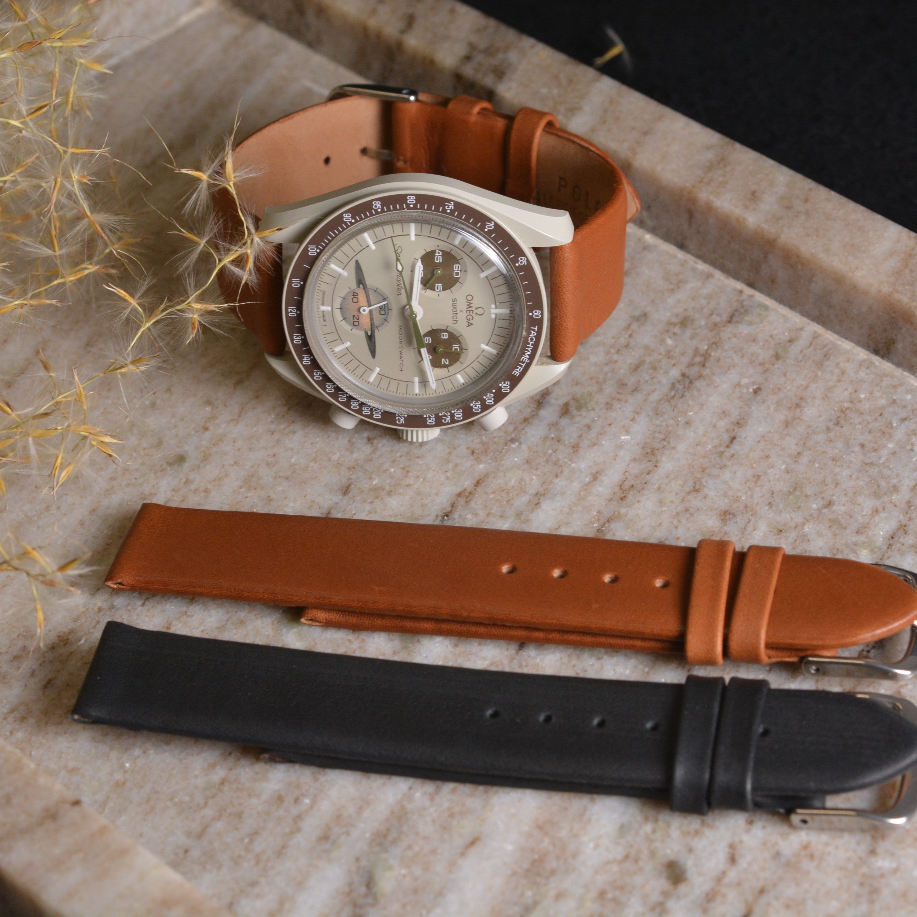 Exquisite Design Glattleder Uhrenarmband in brown and black, showcasing luxurious handcrafted elegance on marble surface.
