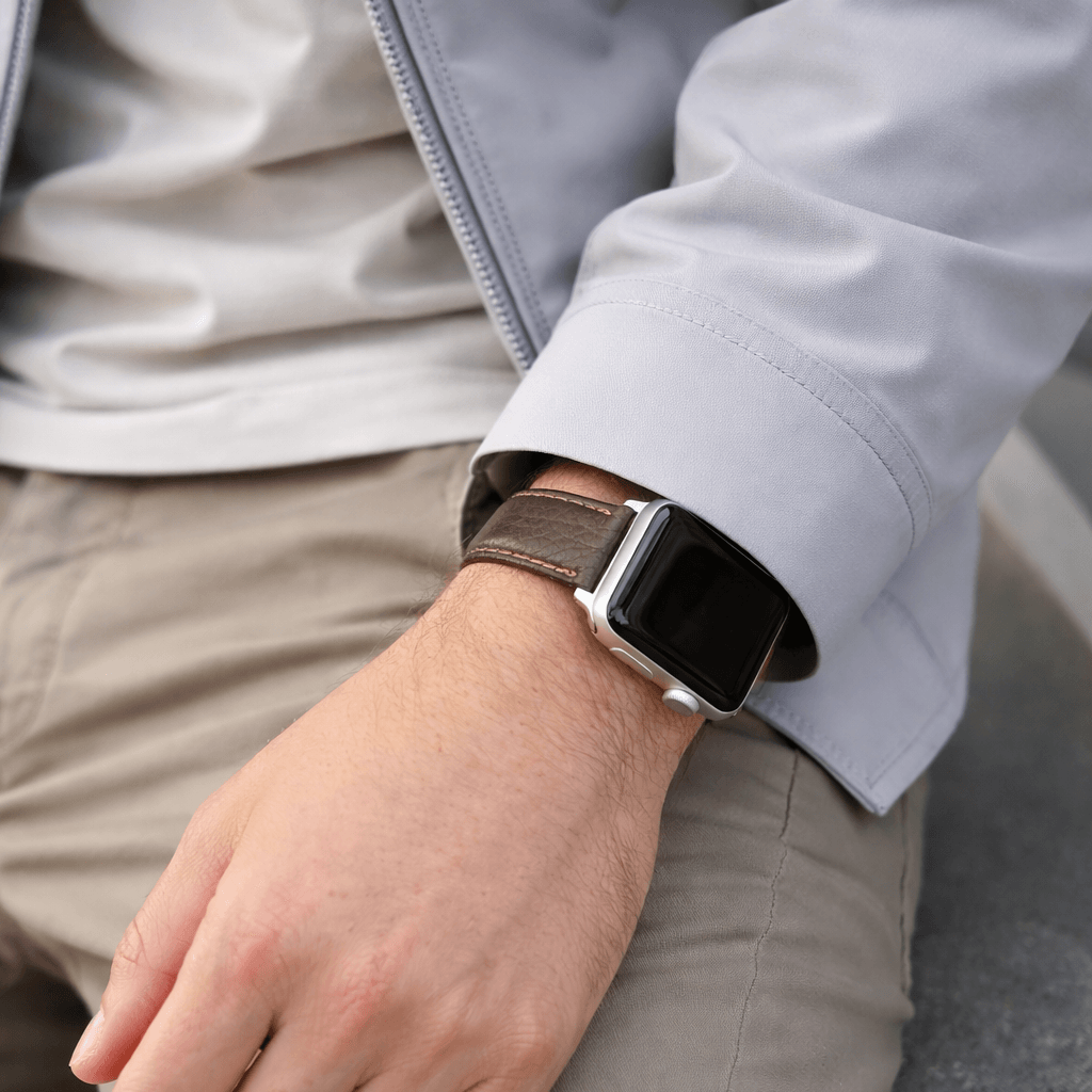 Apple Watch Stierlederarmband Torro Modern Dunkelbraun am Handgelenk eines Mannes mit grauer Jacke und beigem Unterhemd