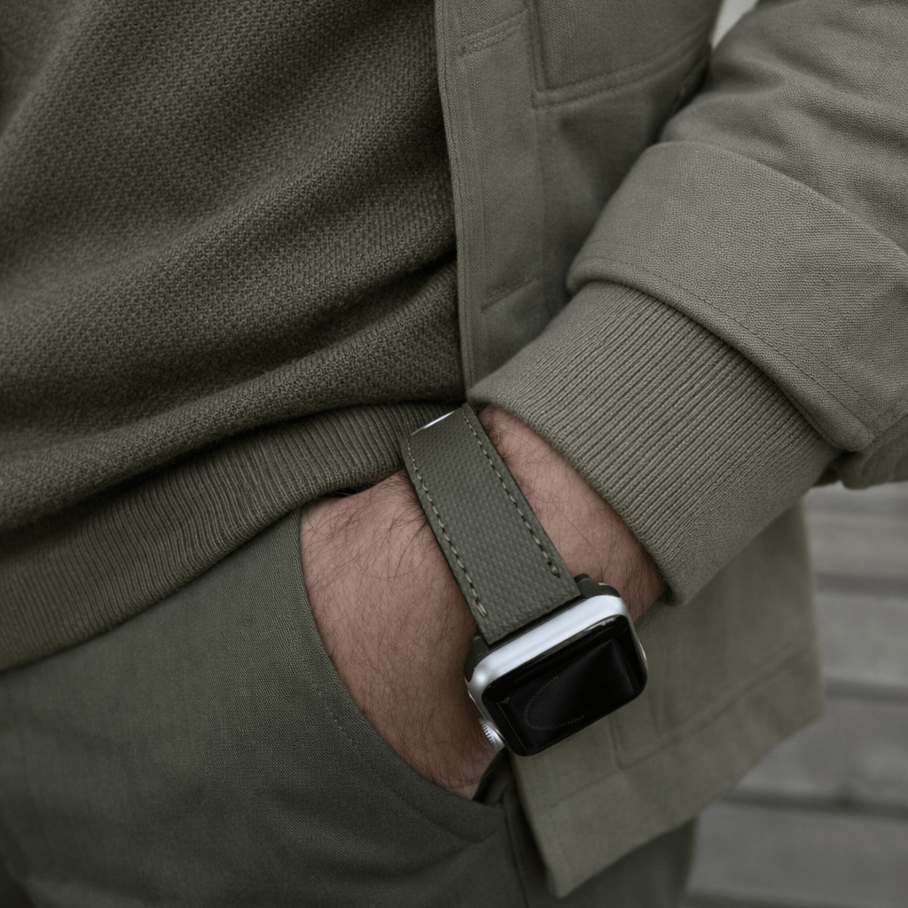 Olivgrünes Apple Watch Lederarmband Wasserfest | Nautilus am Handgelenk eines Mannes im Freien, modern und sportlich