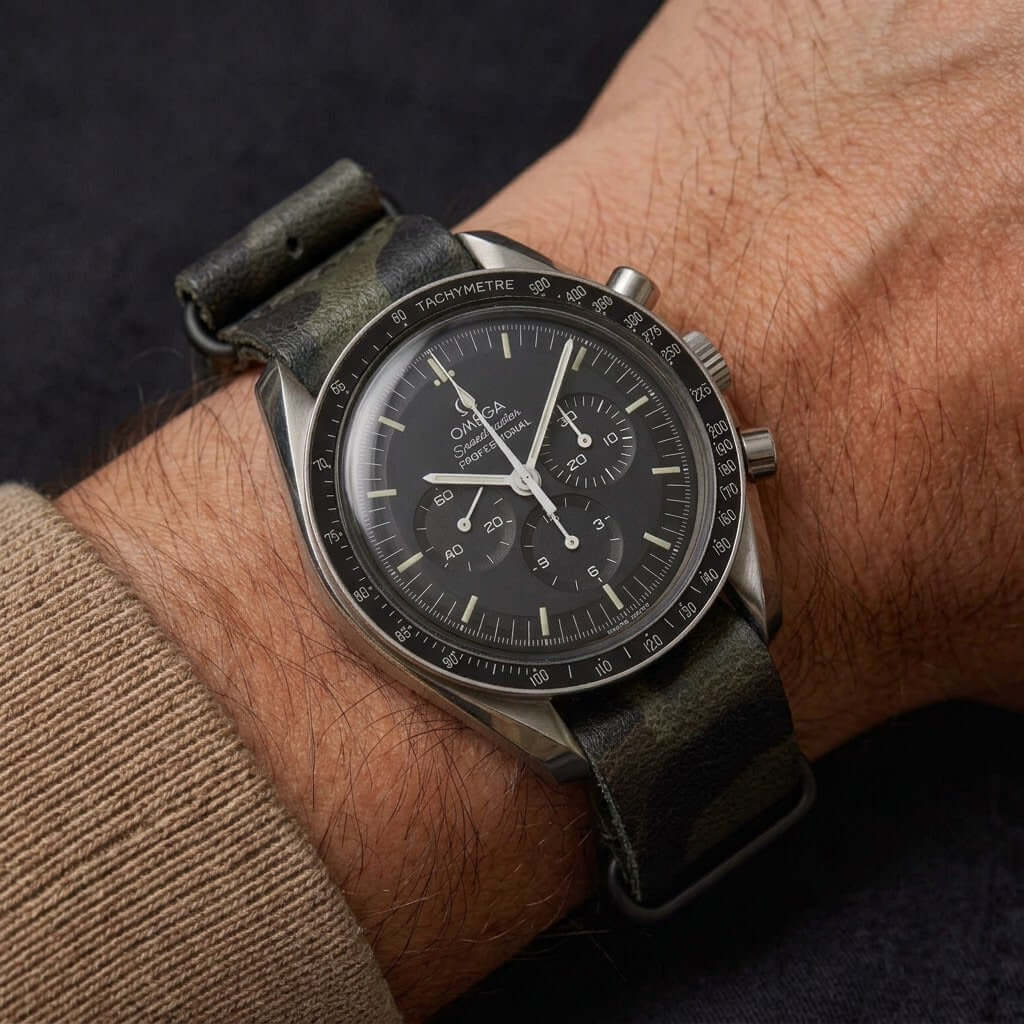 Military – Field Uhrenarmband im Camouflage Look an einer Hand mit einer klassischen Uhr.