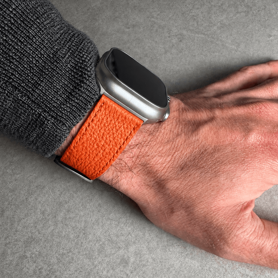 Oranges Lederarmband für Apple Watch aus Togoleder auf Hand, gefertigt aus luxuriösem Togoleder.