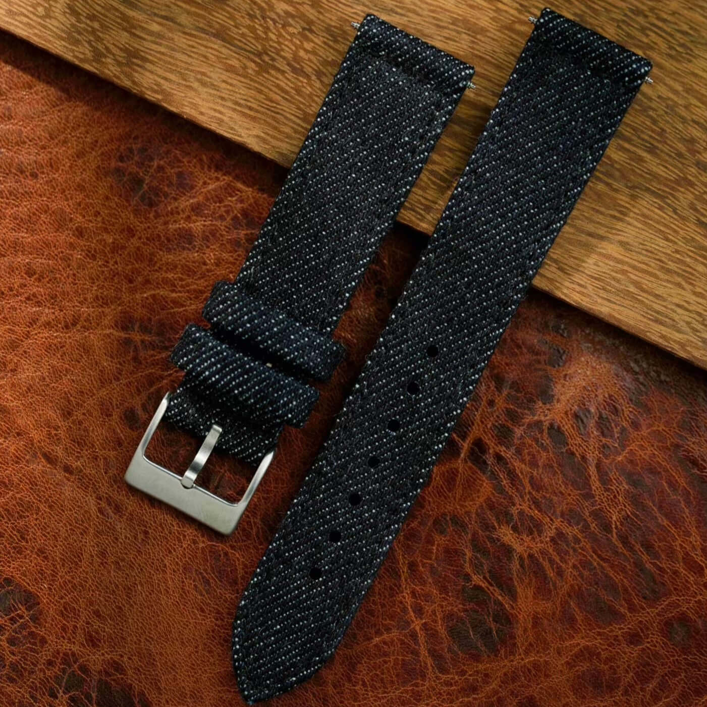 Jeans Uhrenarmband aus japanischem Denim auf Lederunterlage, handgefertigt, langlebig, schweißresistent, urbaner Stil.