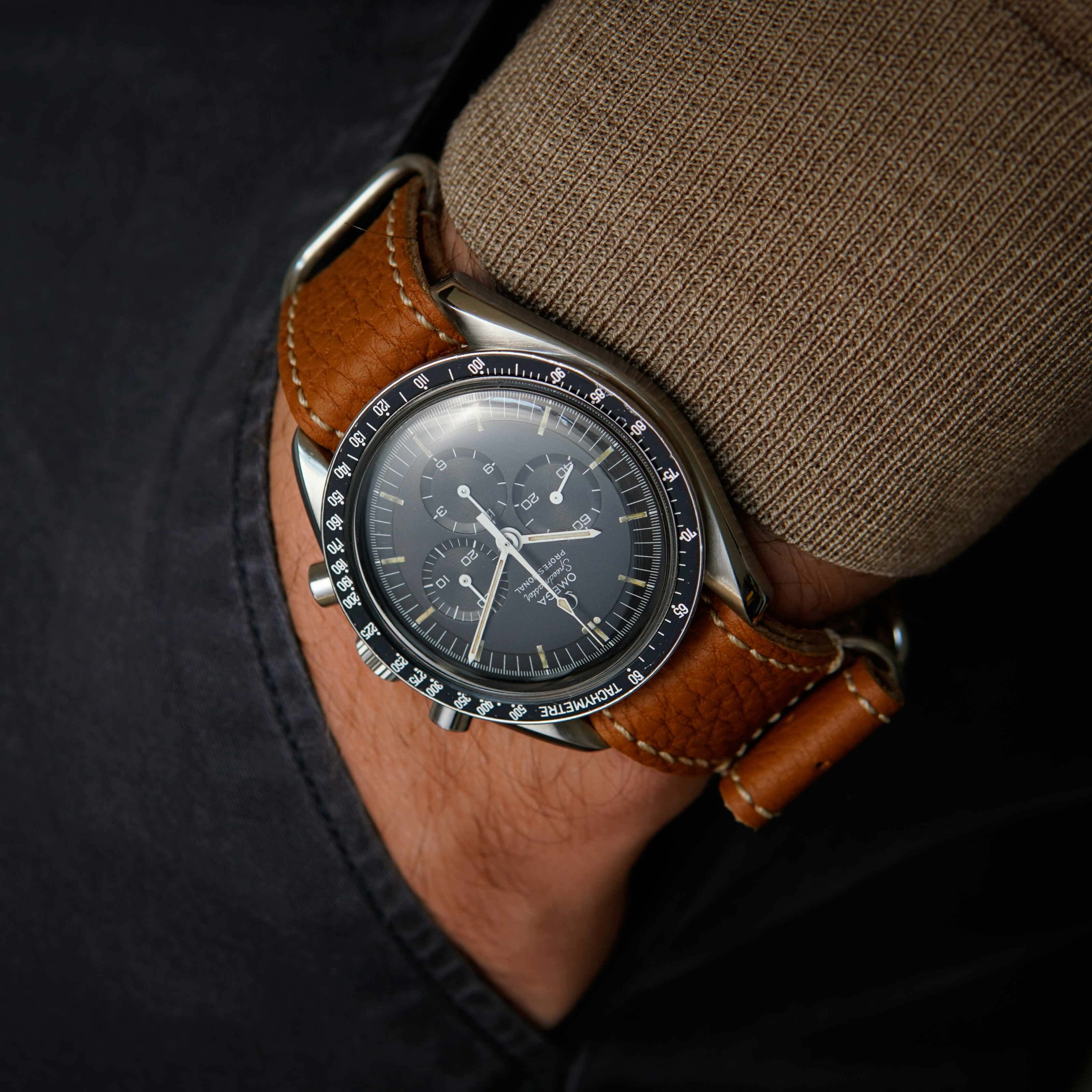 Nahaufnahme eines braunen Nato leder uhrenarmband herren an einem Handgelenk.