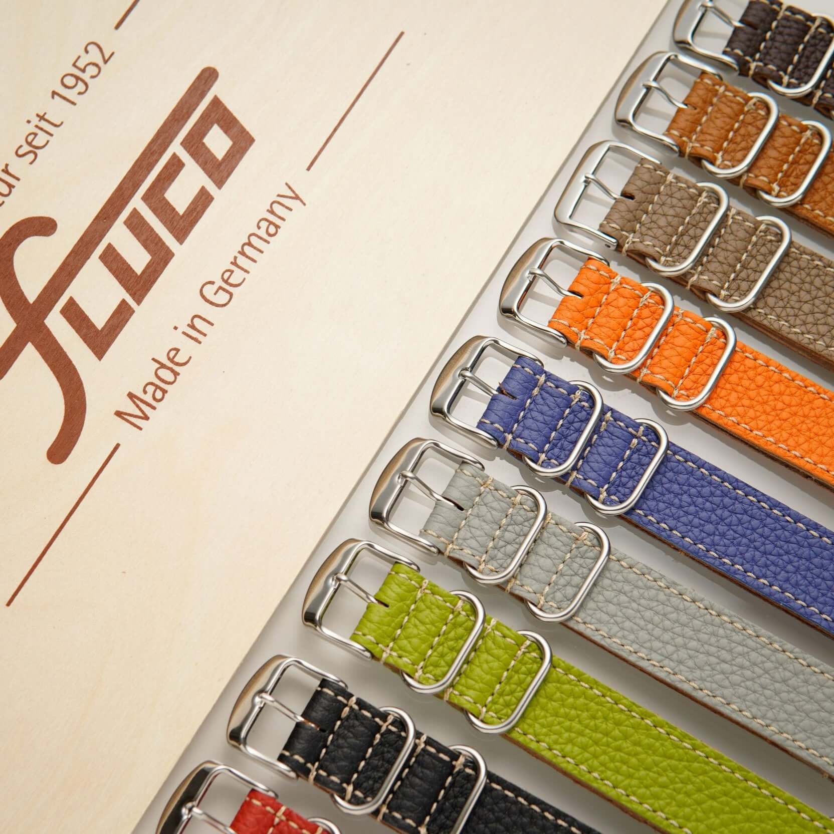 Präsentation verschiedener Nato leder uhrenarmband herren in verschiedenen Farben, auf einem Holzschuber.