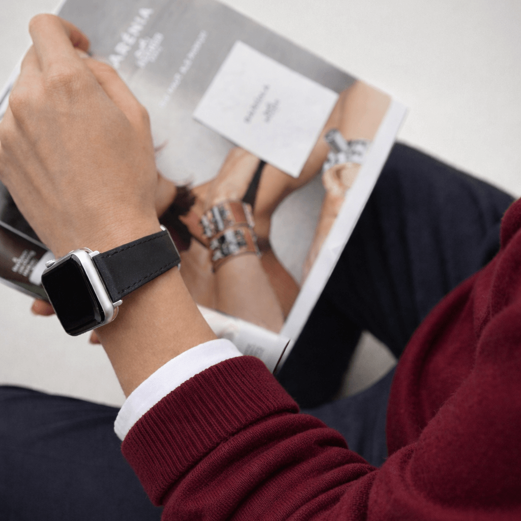 Schwarzes Apple Watch Armband Leder - Bidart bei einem Mann, der eine Zeitschrift liest, stilvoll kombiniert zu einem Outfit.