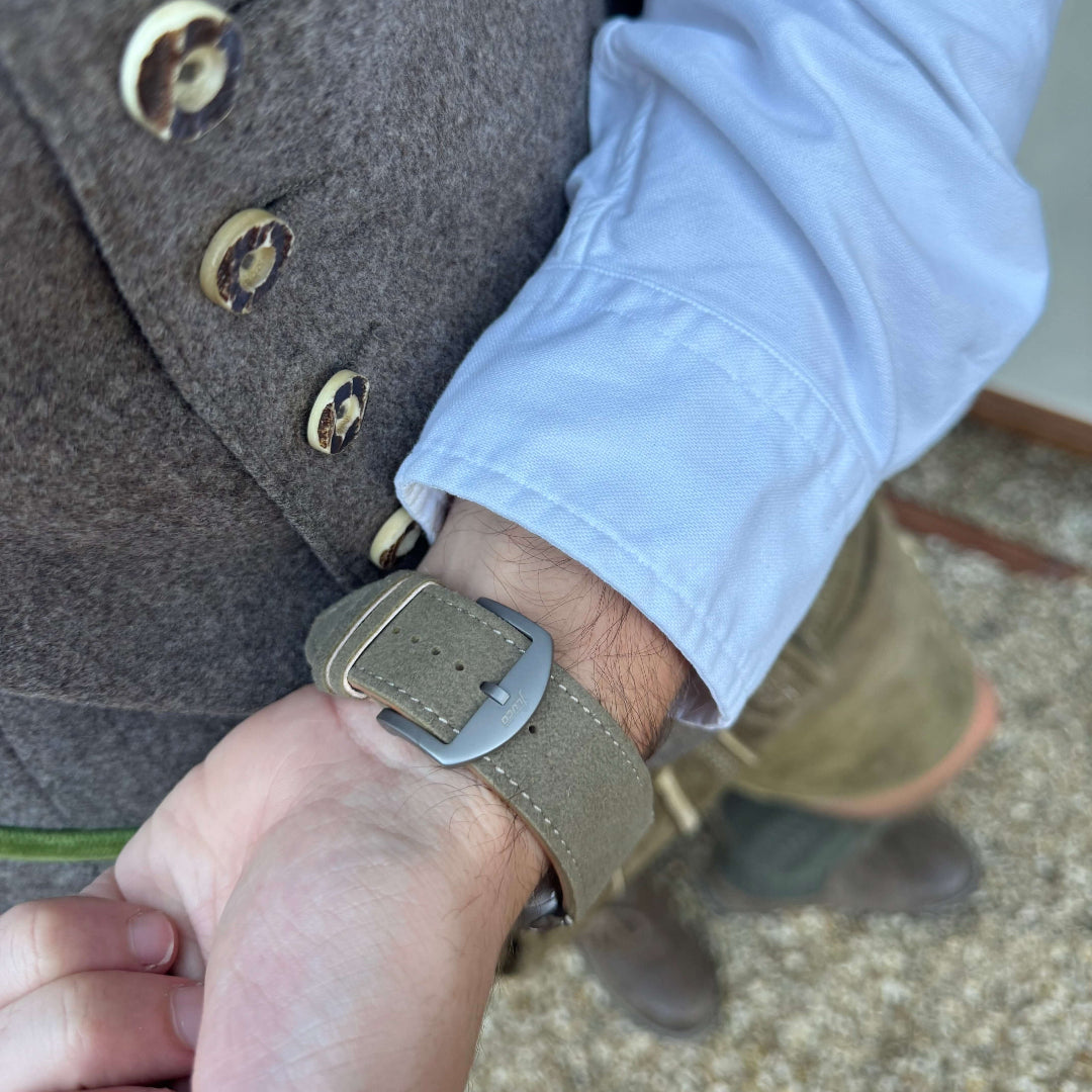 Person trägt ein Beiges Apple Watch Ultra Lederhosen Armband – aus altsämisch gegerbtem Hirschleder, ideal für Oktoberfest.