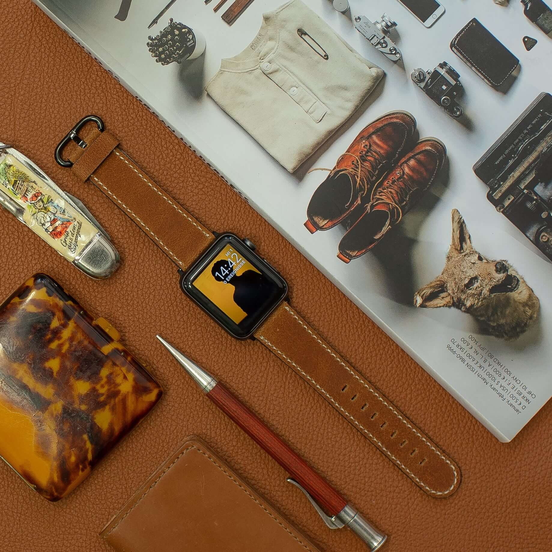 Apple Watch Lederarmband Vintage – Hellbraun mit Accessoires auf braunem Hintergrund, zeitlose Eleganz und vintage rustikaler Look.