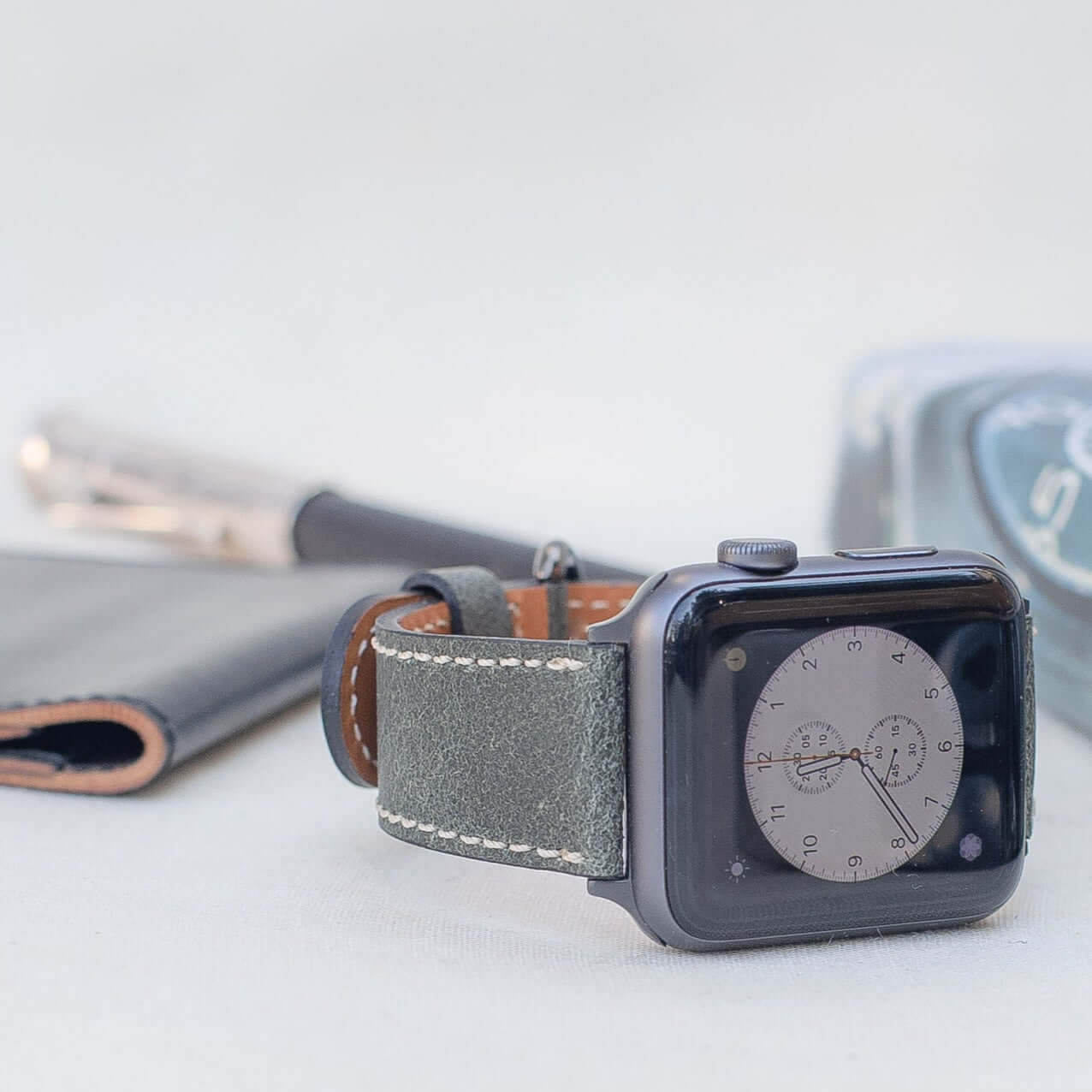 Apple Watch Lederarmband Vintage – Dunkelgrün aus italienischem Rindleder, elegant und rustikal in der Optik, auf einem Tisch liegend.