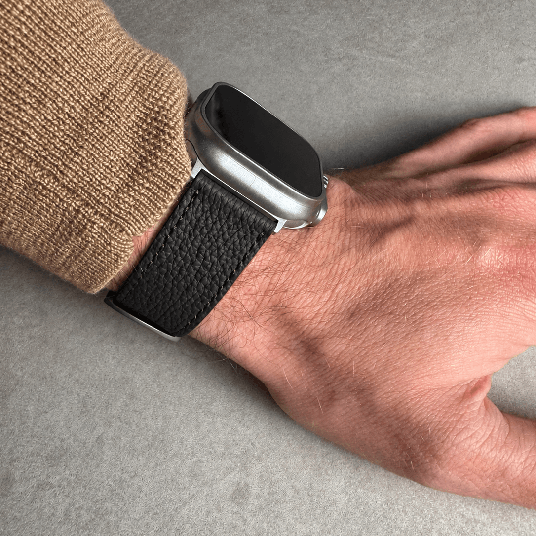 Schwarzes Lederarmband für Apple Watch aus Togoleder an einem Handgelenk, stilvoll und hochwertig.
