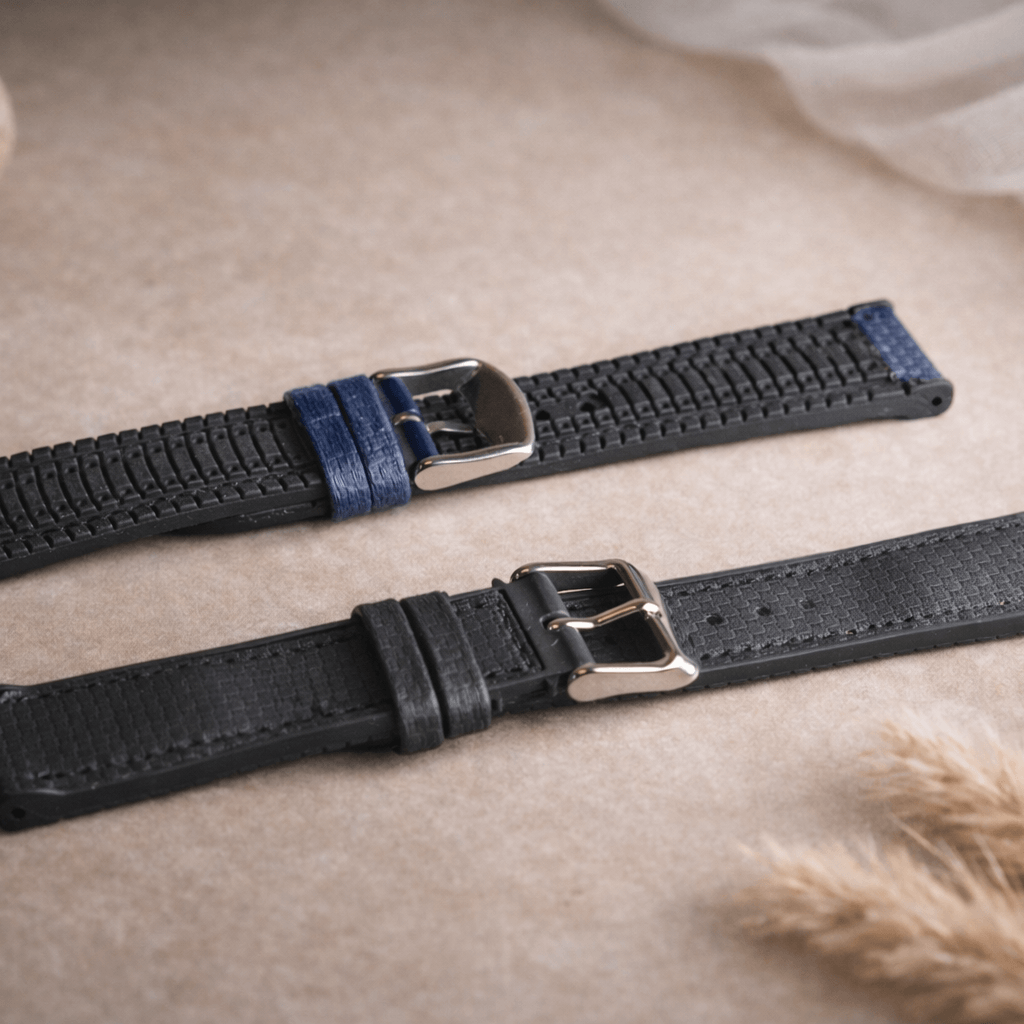 Triton – wasserfestes Performance-Uhrenarmband auf einem Tisch mit zwei Varianten in Schwarz und Blau, langlebig und robust.