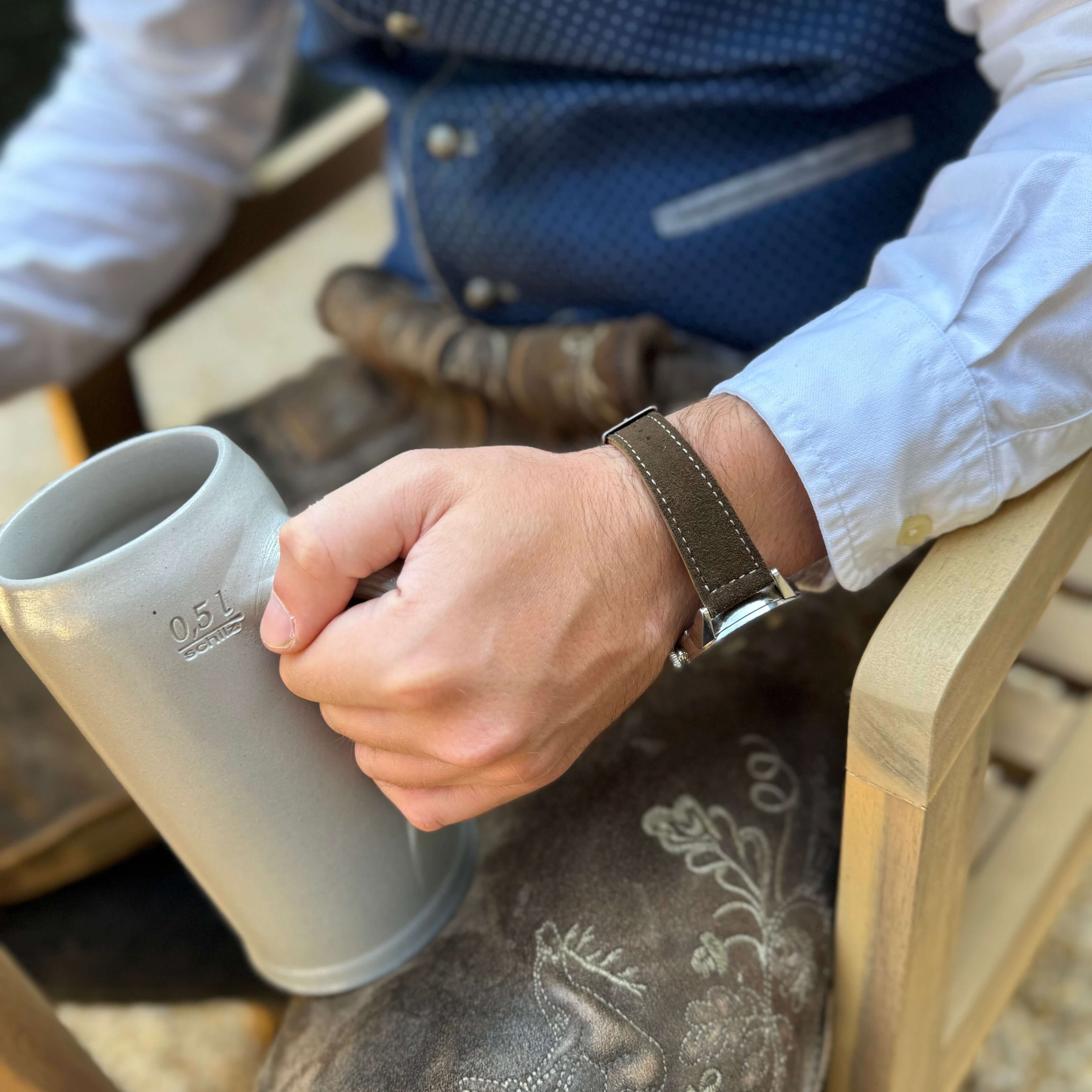 Alt Tag: 20mm Uhrenarmband aus echtem Lederhosenleder – altsämisch gegerbtes Hirschleder braun getragen von einem Mann mit Bierkrug