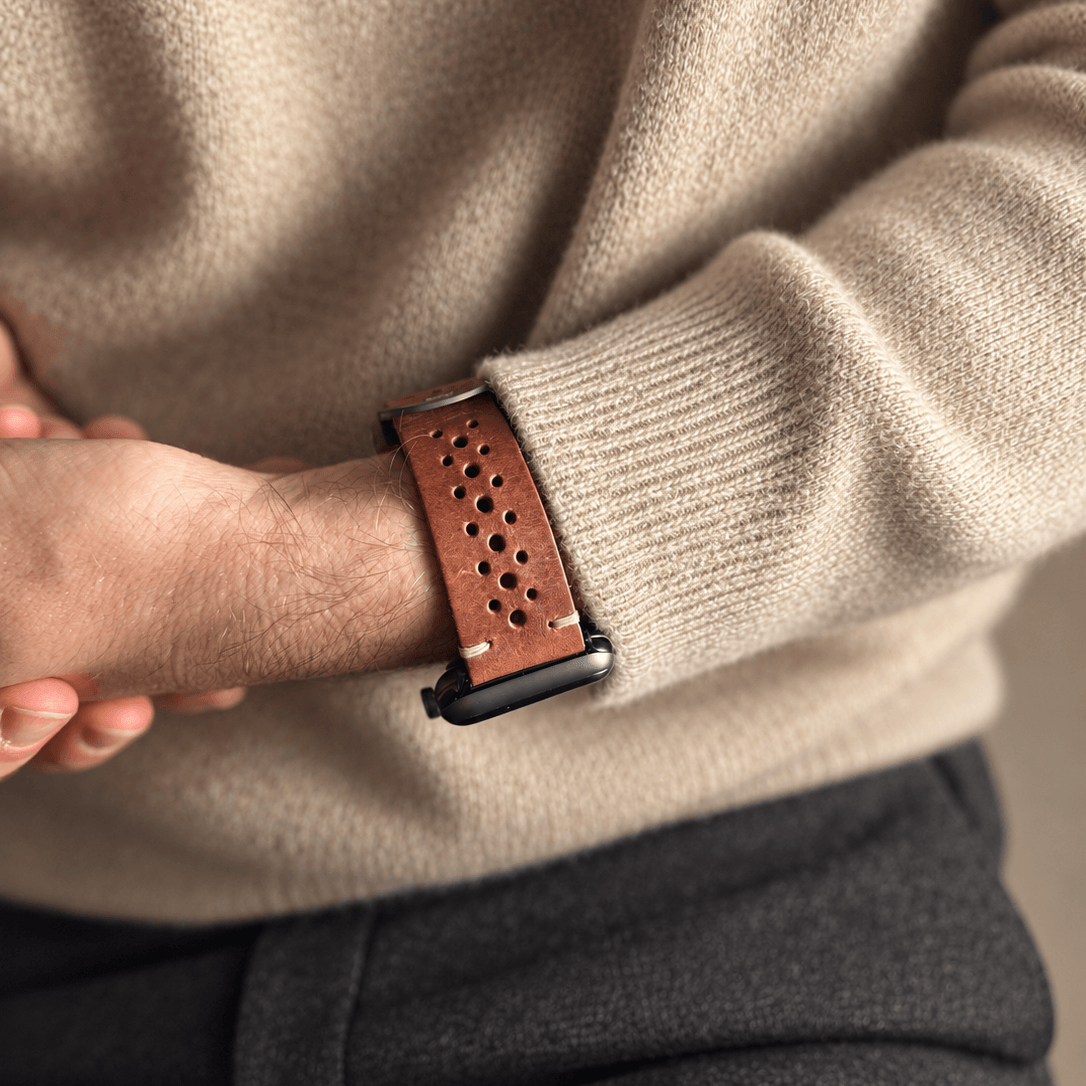 Rallye Lederband für Apple Watch – Hellbraun an einem Handgelenk, kombiniert mit einem beigen Pullover.