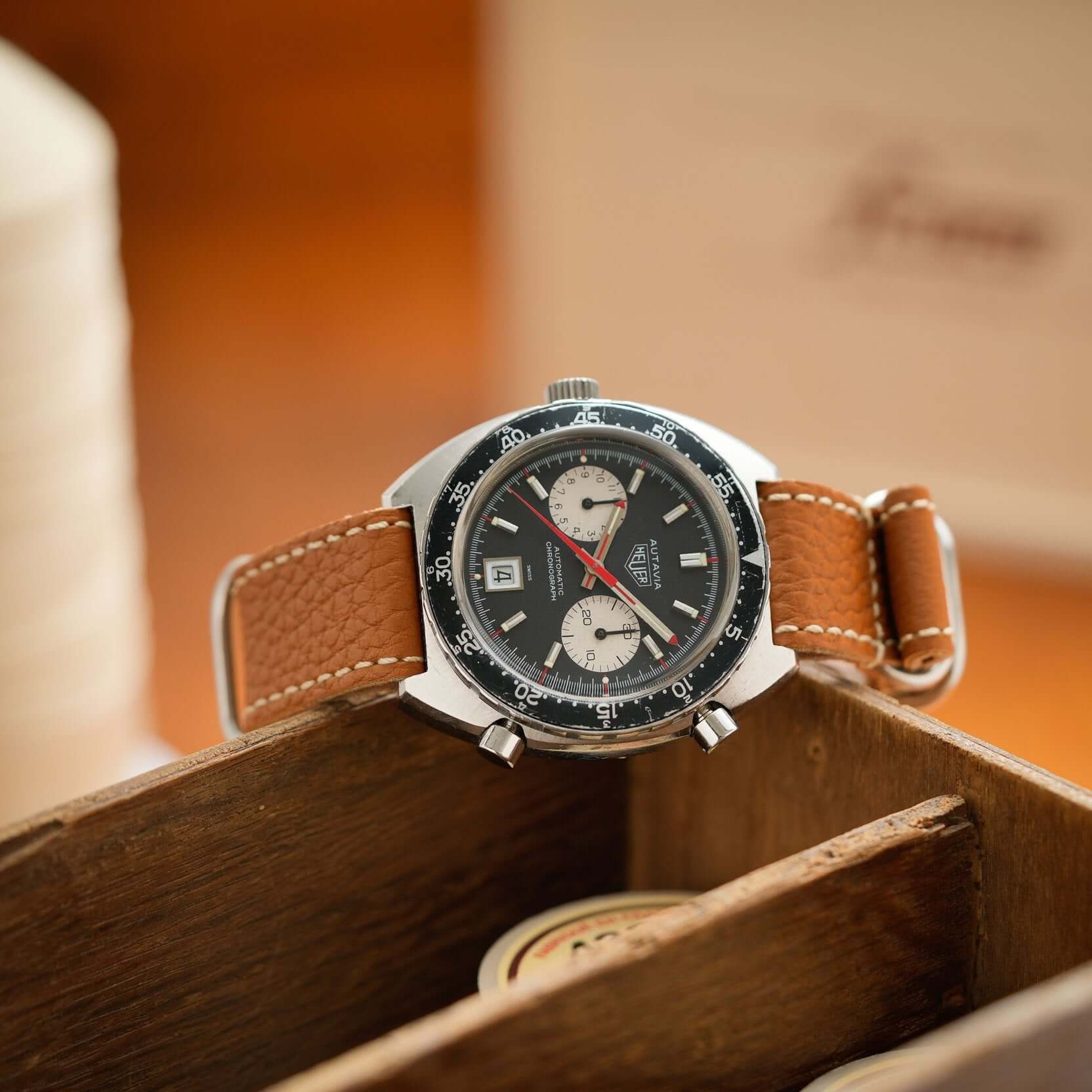 Uhren mit Nato leder uhrenarmband herren in braun und grau, auf einem Holzbrett arrangiert.