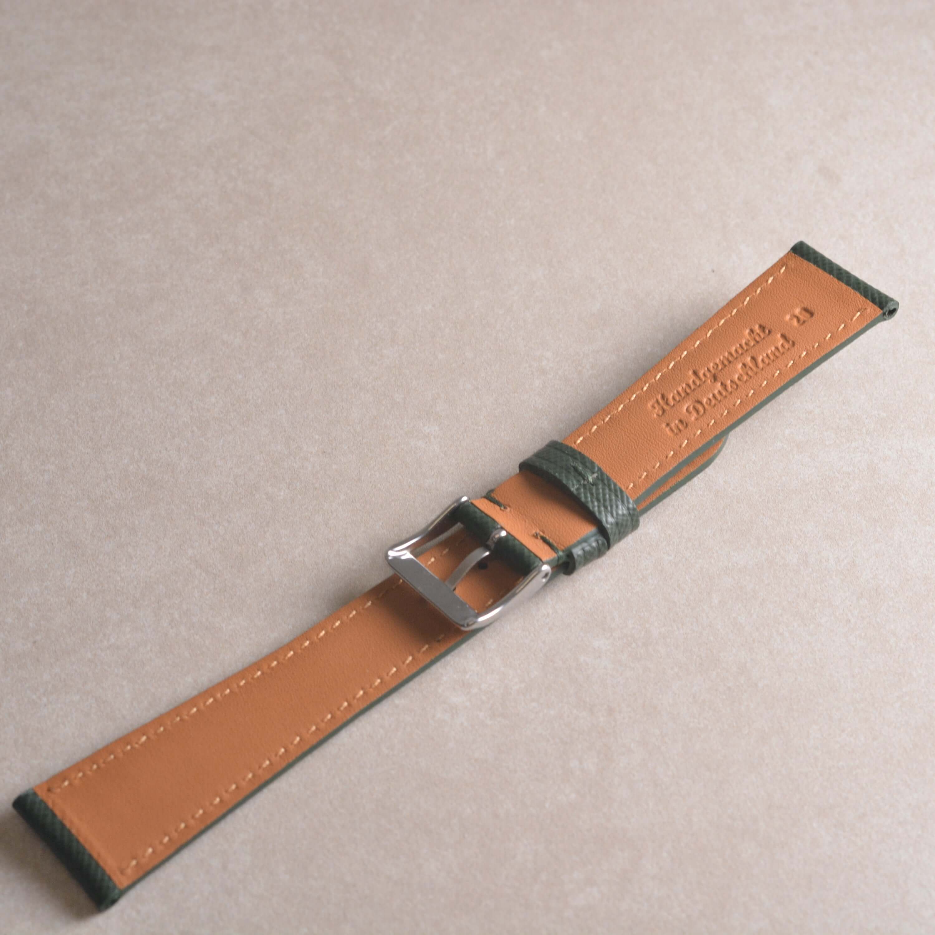 Saffiano – Uhrenarmband mit charakteristischer Saffiano Kreuzprägung auf beige Hintergrund.