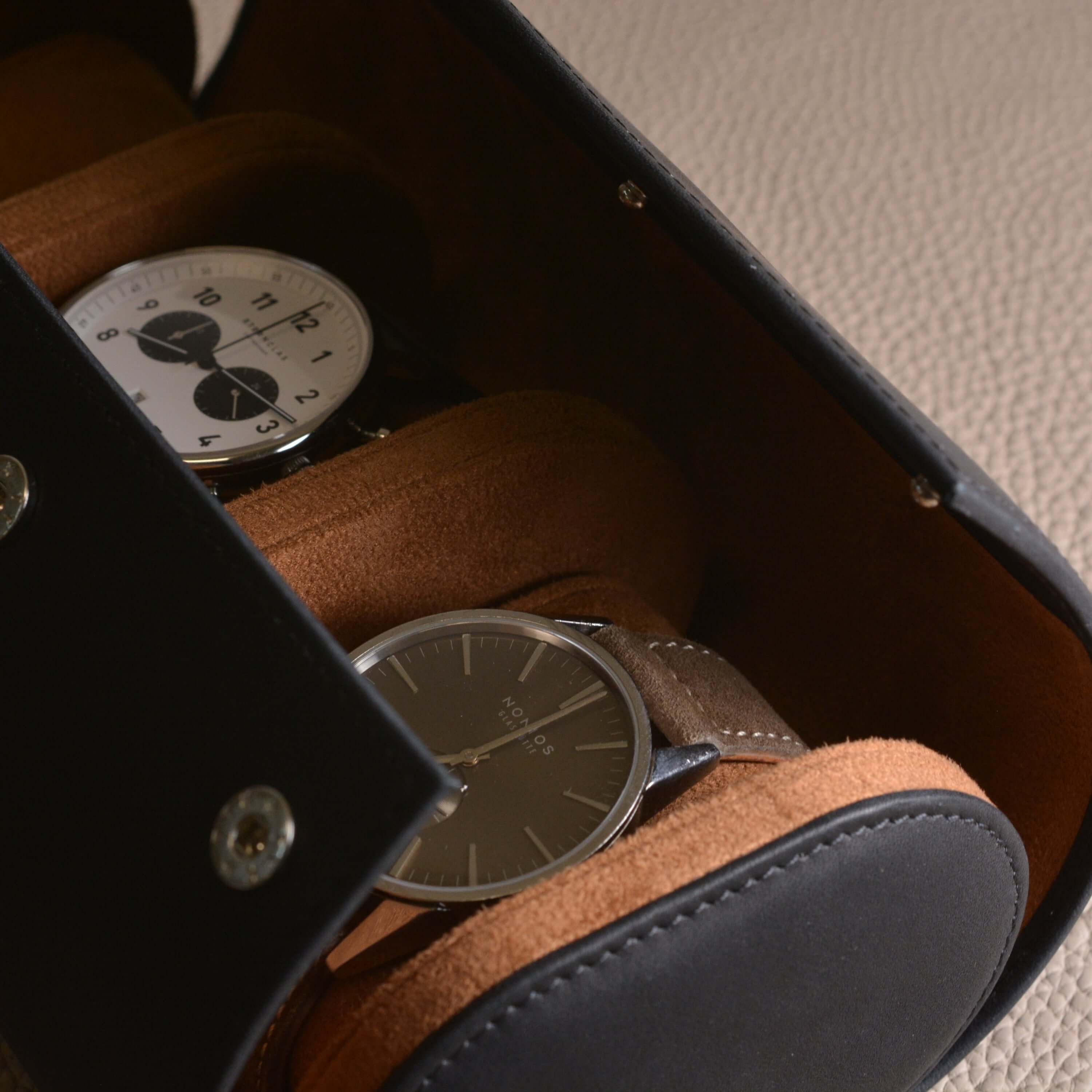 Luxurious handcrafted 3-watch roll in Barenia leather showcasing two watches, ideal for travel protection and elegant storage.