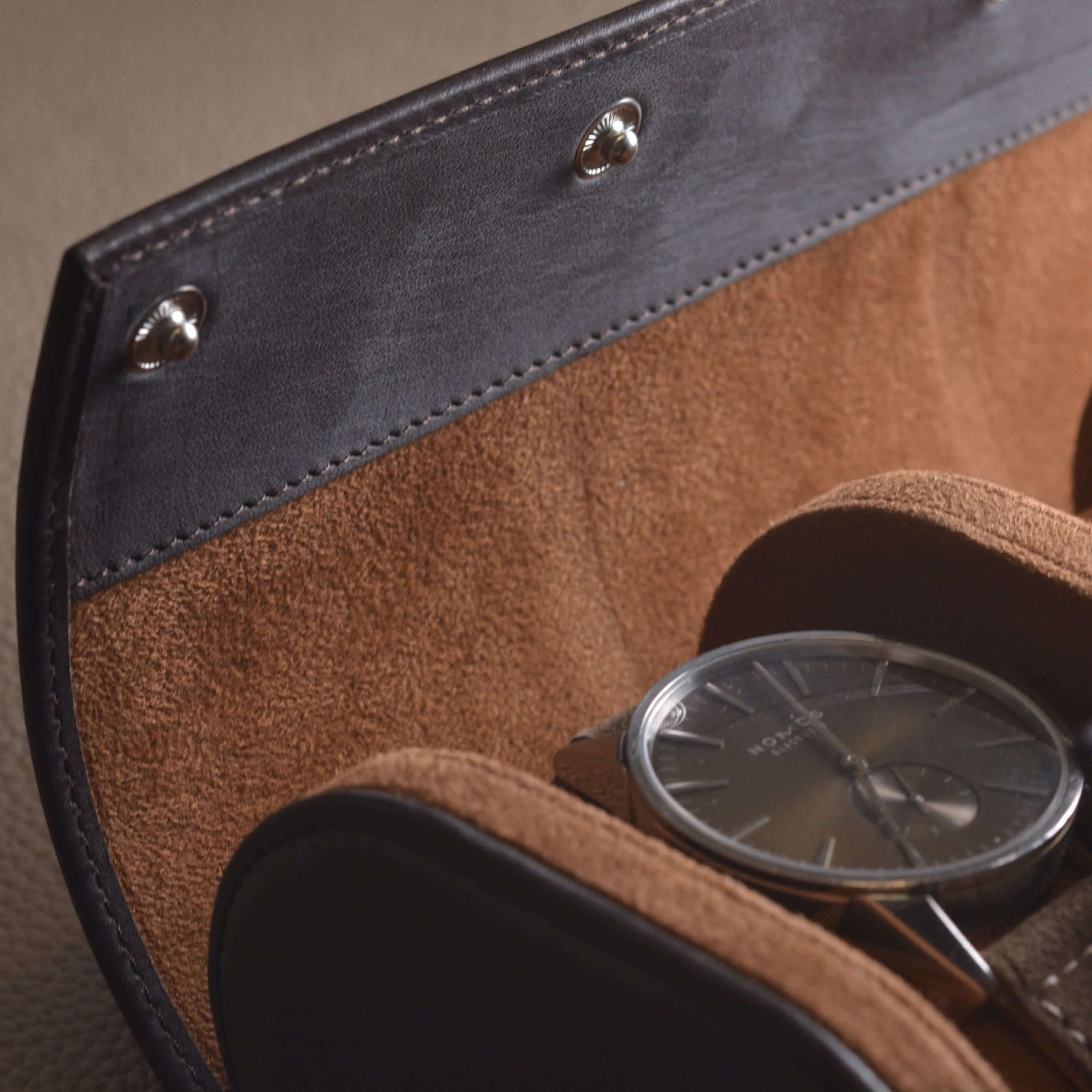 Close-up of a luxury watch in a handcrafted Barenia leather watch roll, highlighting the elegant design and premium materials.