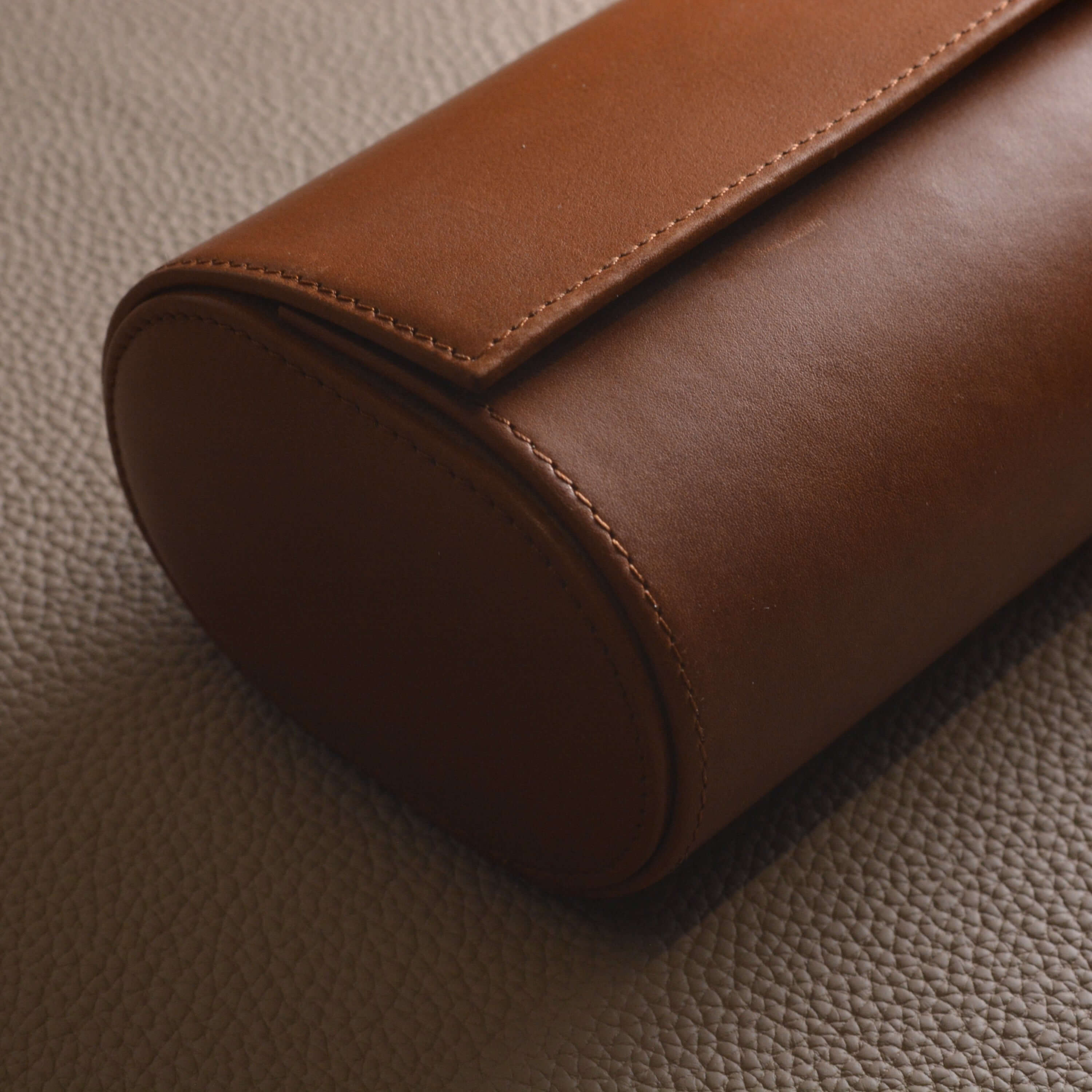 Luxurious Barenia leather watch roll in brown, crafted for holding three watches. Stylish accessory with premium smooth leather.