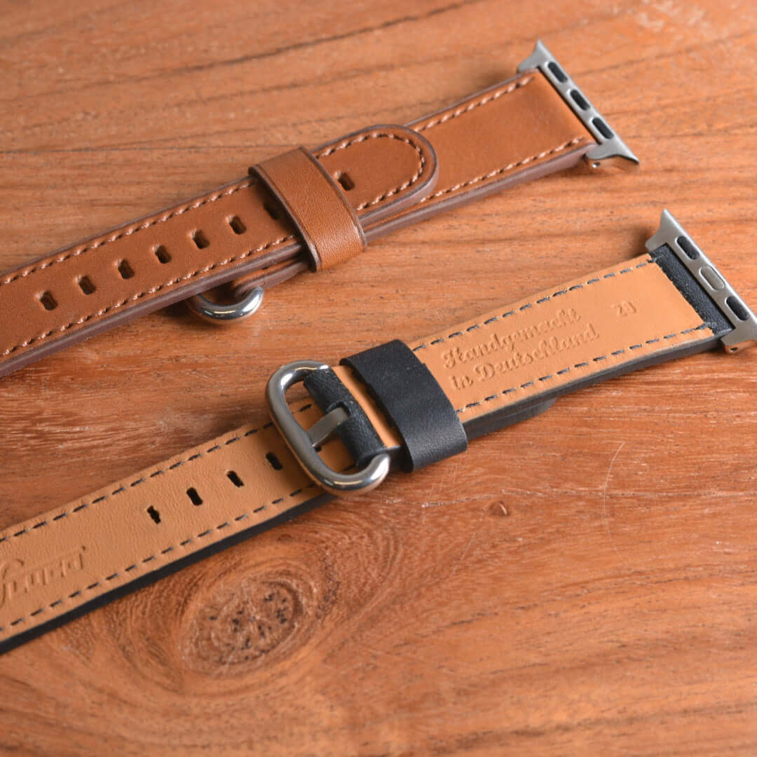 Edles schwarzes Apple Watch Armband Leder - Bidart von FLUCO, aus feinstem Barenia Leder, auf Holzoberfläche präsentiert.