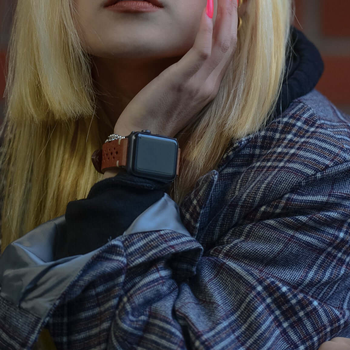 Frau mit Apple Watch und hellbraunem Rallye Lederband, moderne Mode und Lederhandwerkskunst