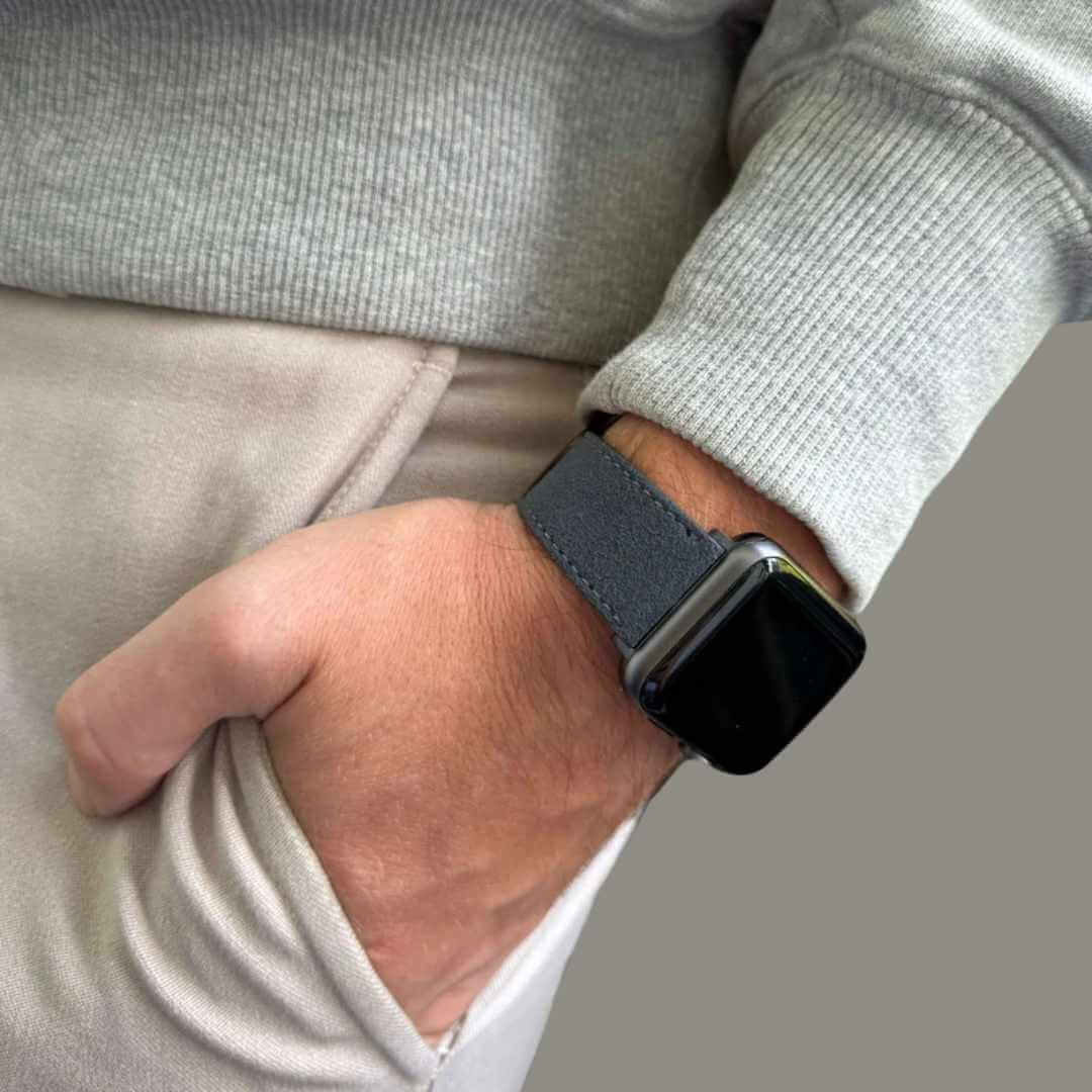 Alcantara – Apple Watch Armband in Dunkelgrau, getragen an einem Handgelenk, passend zu jedem Outfit, aus italienischem Alcantara gefertigt.