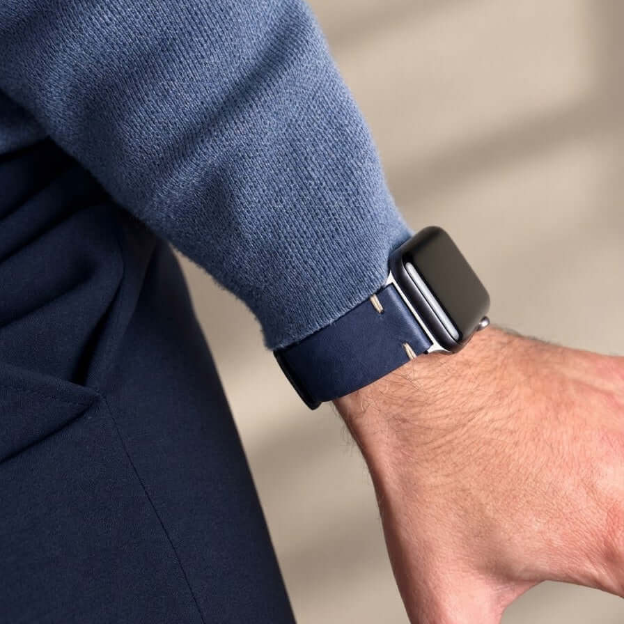 Hunter Apple Watch Armband Leder Blau an einem Handgelenk, kombiniert mit blauer Kleidung.