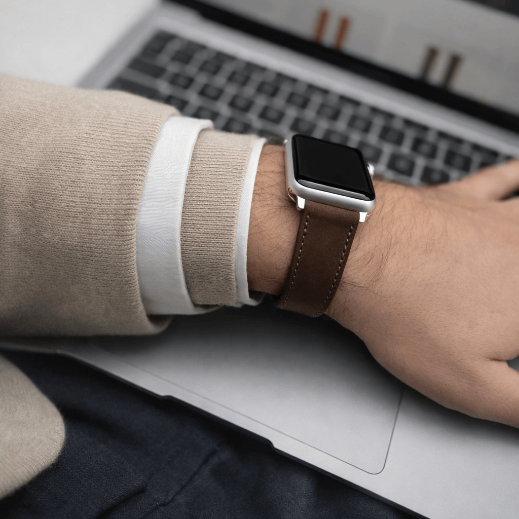 Mountain Apple Watch Lederarmband – Dunkelbraun am Handgelenk eines Mannes, stilvoll auf einem Laptop abgebildet.