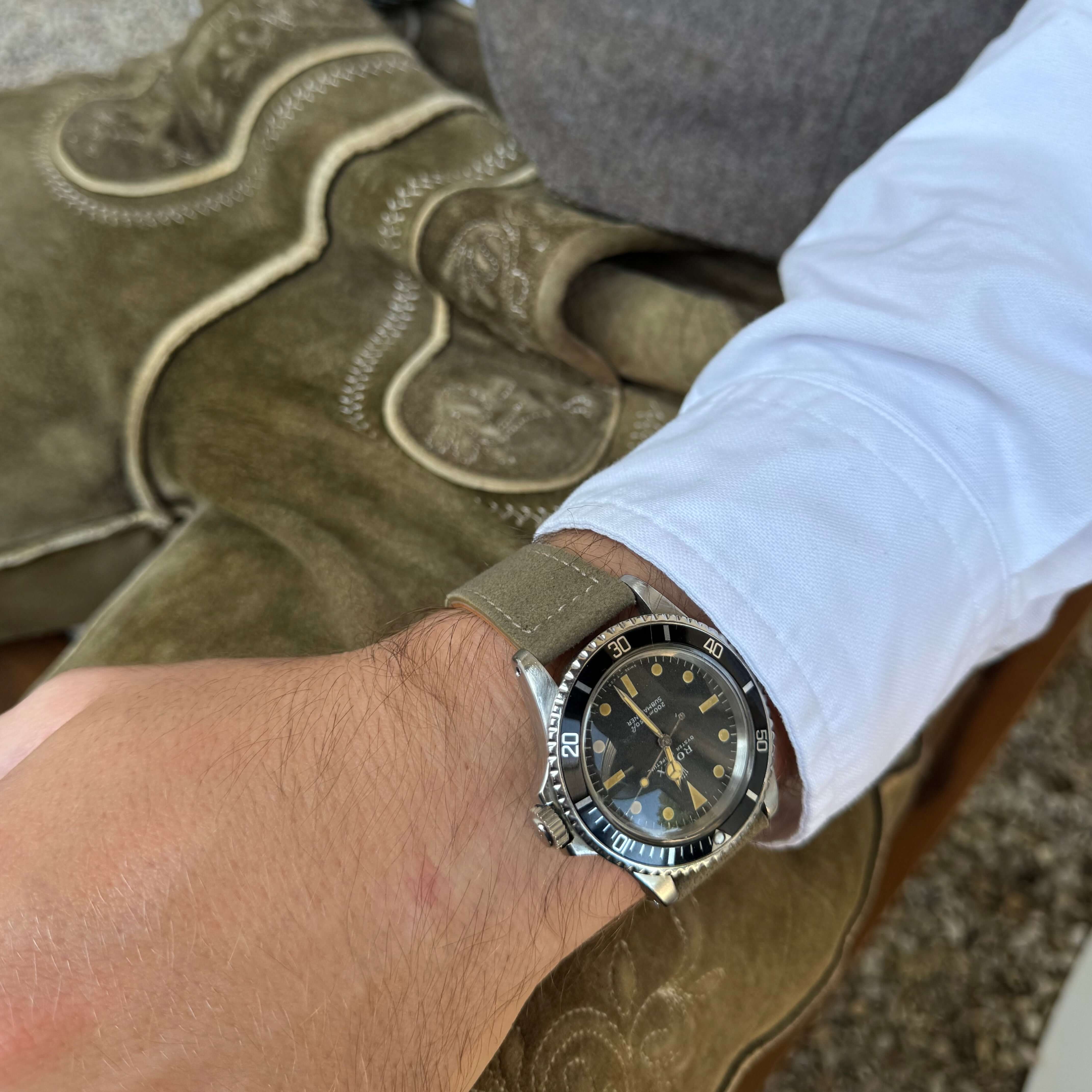 20mm Uhrenarmband aus echtem Lederhosenleder – altsämisch gegerbtes Hirschleder, getragen an einem Handgelenk neben traditioneller Kleidung.