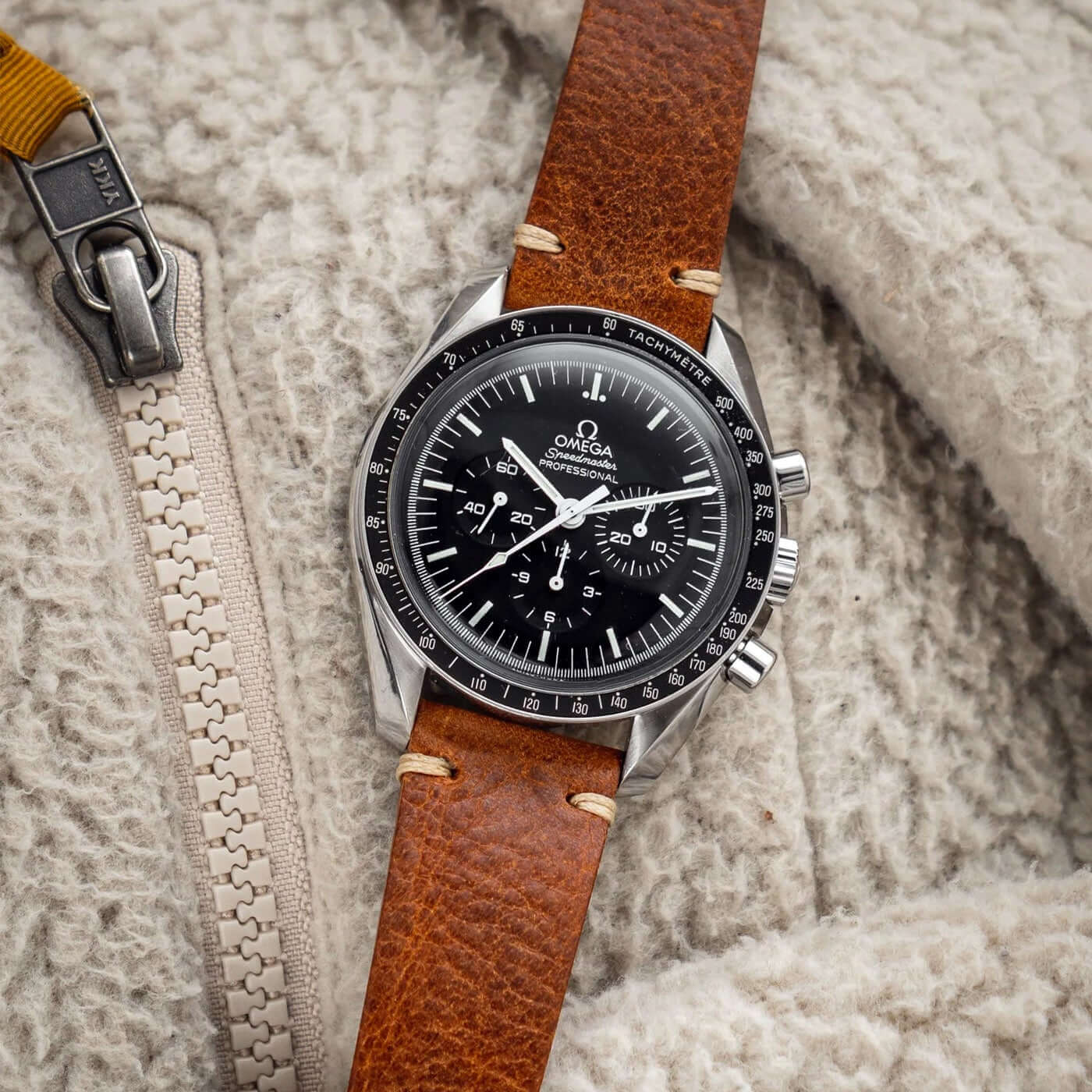 Hunter – Uhrenarmband aus toskanischem Vintage-Rindleder an einer klassischen Armbanduhr auf Wollstoff platziert.