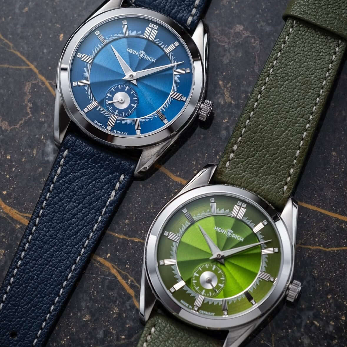 Zwei Uhren mit Biarritz Uhrenarmband Leder hochwertig in Oliv und Blau auf Marmortisch, stilvoll und elegant.