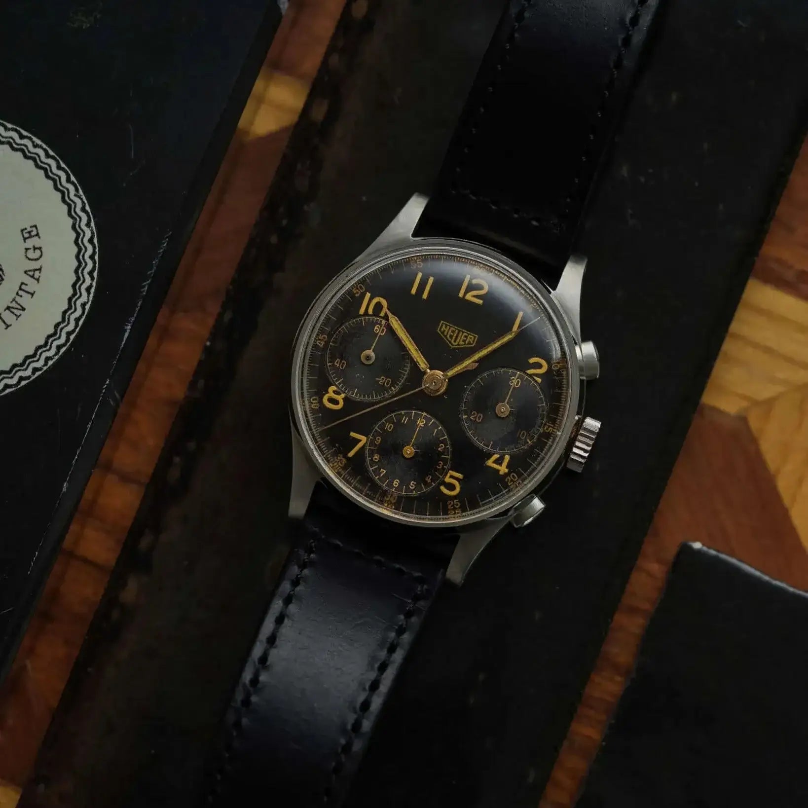 Vintage Uhr mit Horween Chrom Excel Leder Uhrenarmband in Schwarz auf Holztisch