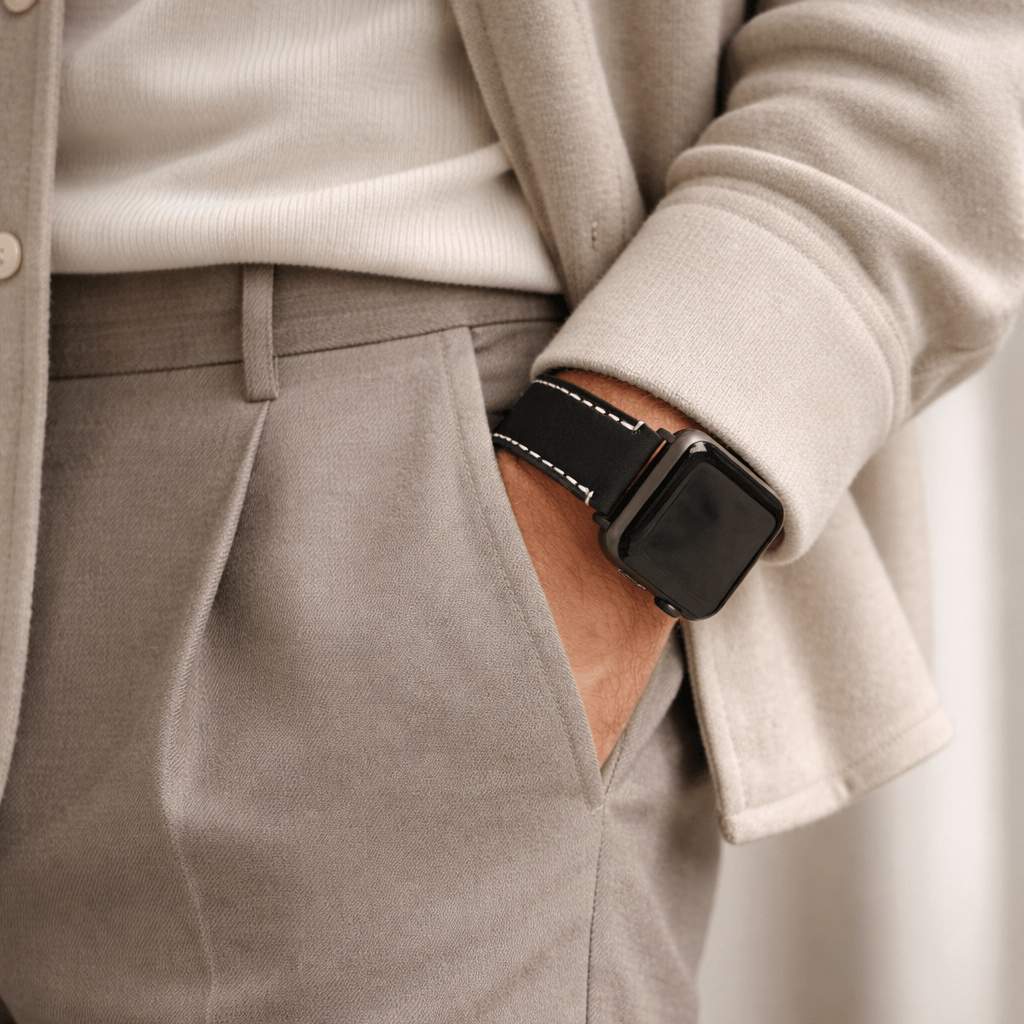 Apple Watch Ultra Lederarmband – Schwarz, extra breit 24 mm am Handgelenk einer Person in smarter Kleidung.