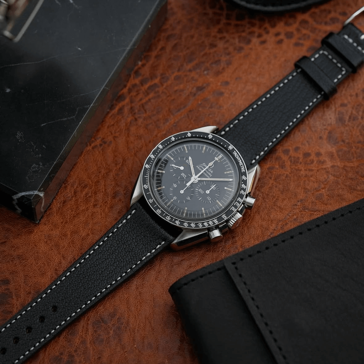 Elegantes Biarritz Uhrenarmband Leder hochwertig in Schwarz, perfekt kombiniert mit einer stilvollen Armbanduhr auf Lederuntergrund.