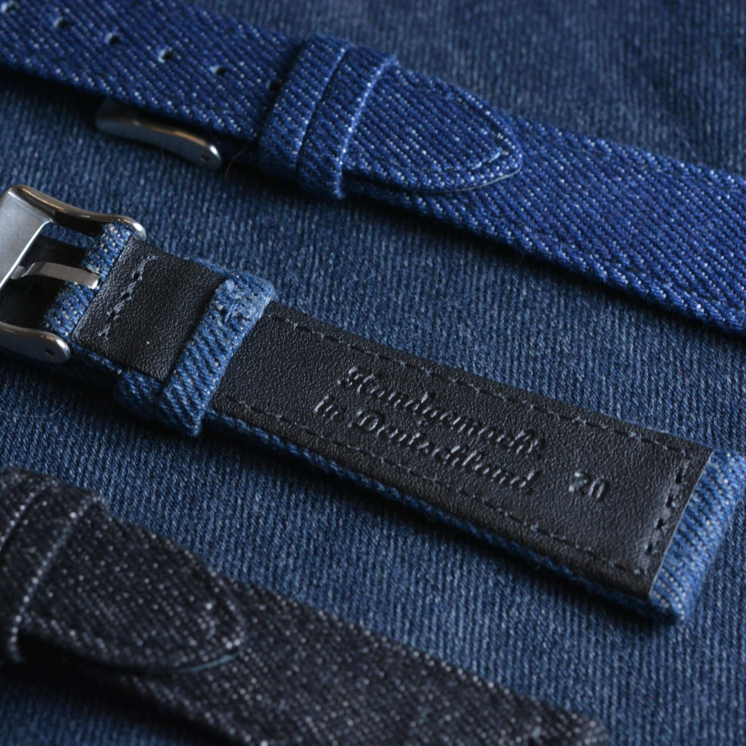 Jeans Uhrenarmband aus japanischem Denim mit schwarzem Kalbleder gefüttert, urbaner Stil auf Jeansstoff-Untergrund.