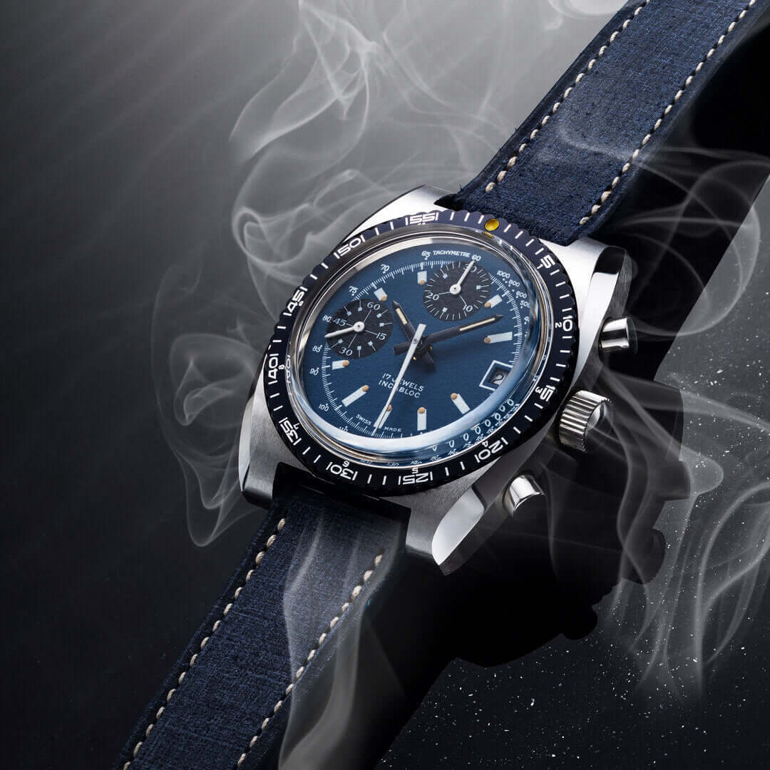 Luxus-Armbanduhr mit blauem Zifferblatt und Lederarmband, umgeben von Rauch, für elegante und stilvolle Herrenmode.