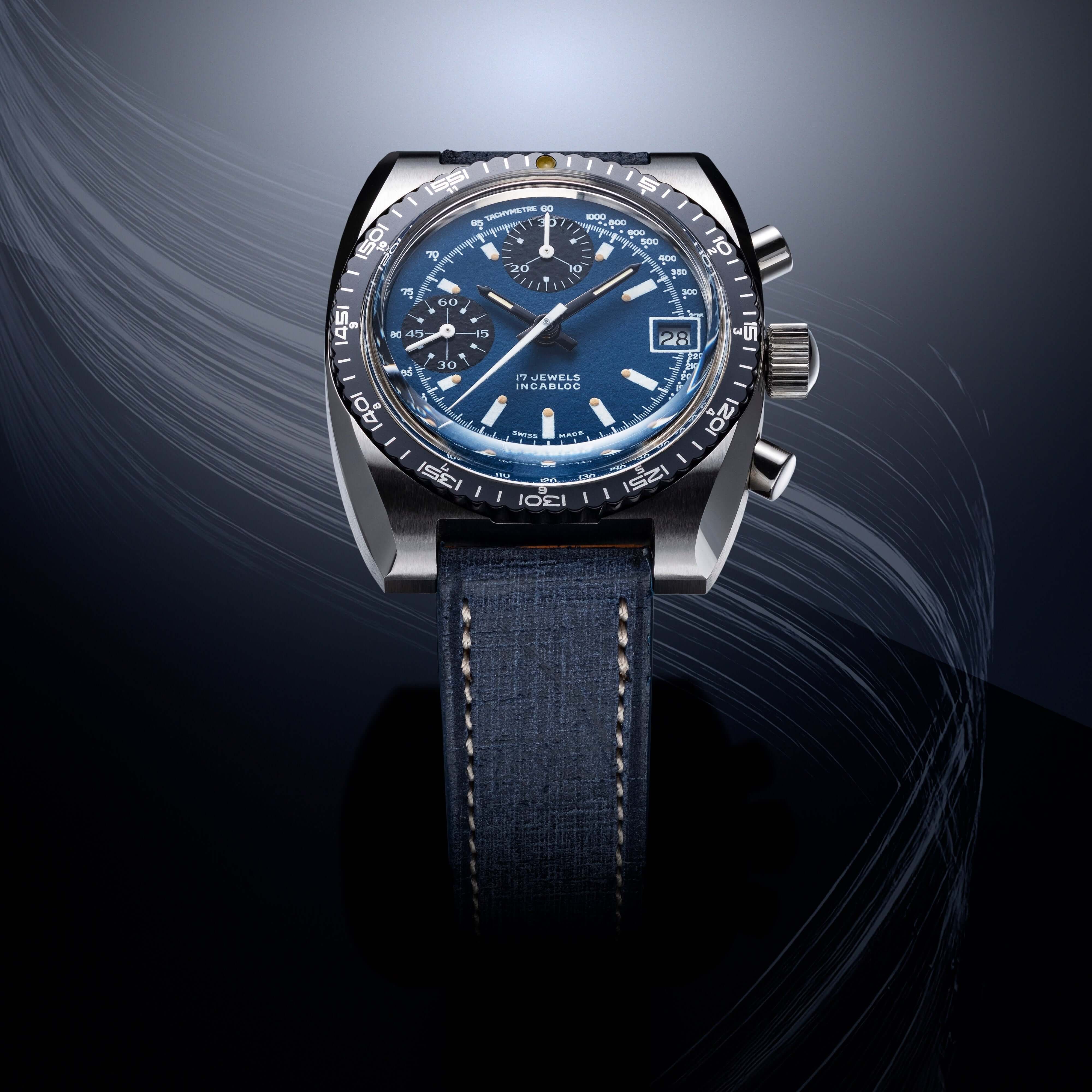 Hochwertige Armbanduhr mit blauem Zifferblatt und Edelstahlgehäuse, präsentiert auf dunkelblauem Lederarmband auf abstraktem Hintergrund.