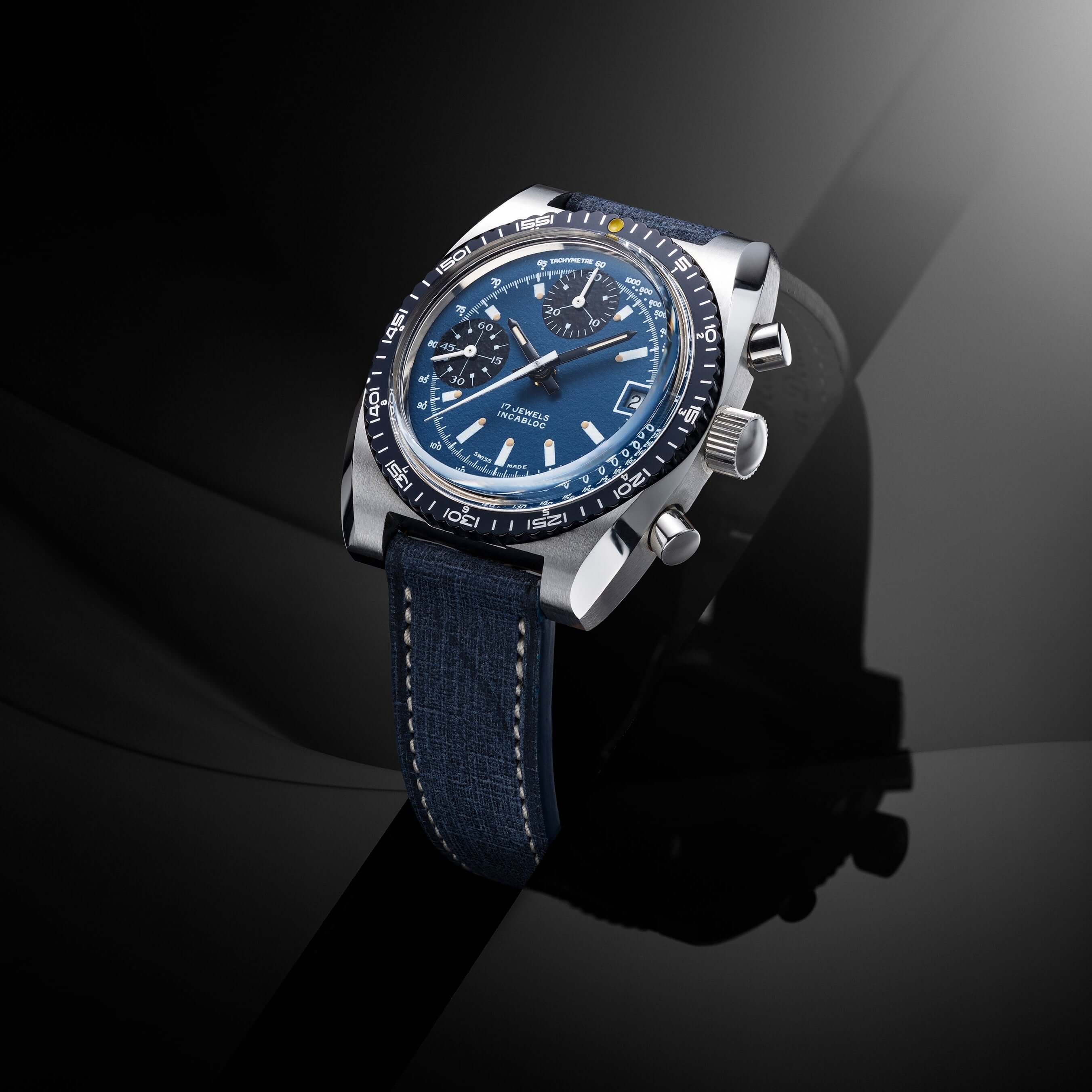 Edle Herrenuhr mit blauem Zifferblatt und hochwertigem Armband. Luxuriöses Design auf einem eleganten, dunklen Hintergrund.